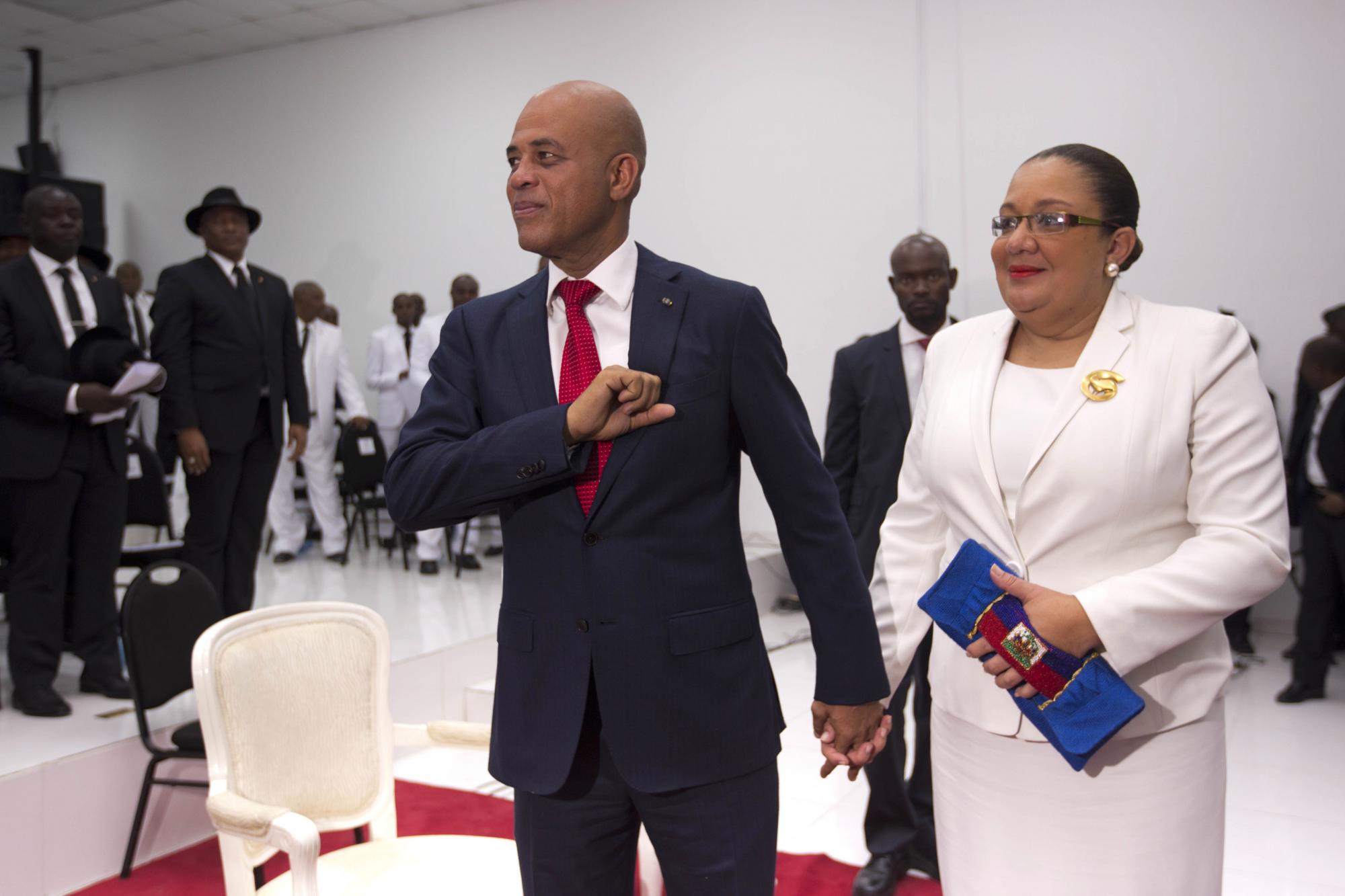El expresidente haitino Michel Martelly, junto a su esposa Shopia, se despide de los presentes en el Parlamento.