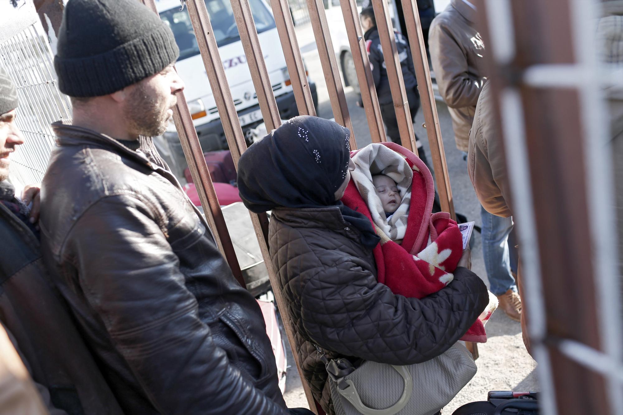 Refugiados esperan en el paso fronterizo de Öncüpinar, en la provincia de Kilis, Turquía, hoy, 8 de febrero de 2016, para regresar a Siria. 