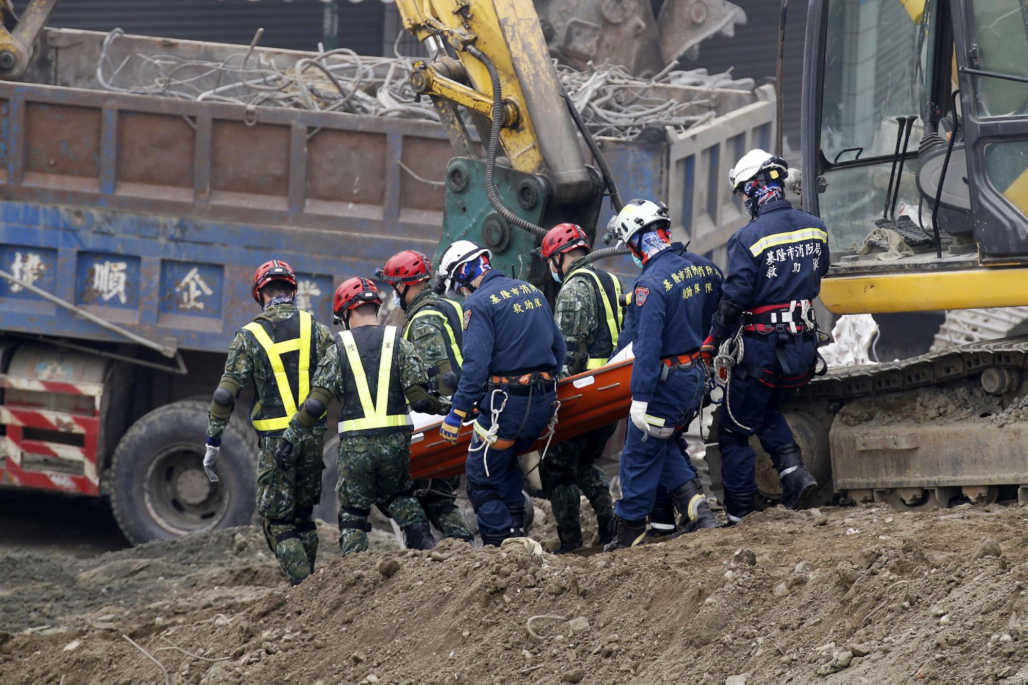 Miembros de los servicios de rescate recuperan el cuerpo sin vida de una de las víctimas mortales del terremoto de 6,4 grados del pasado sábado en Tainan (Taiwán) hoy, 10 de febrero de 2016. 