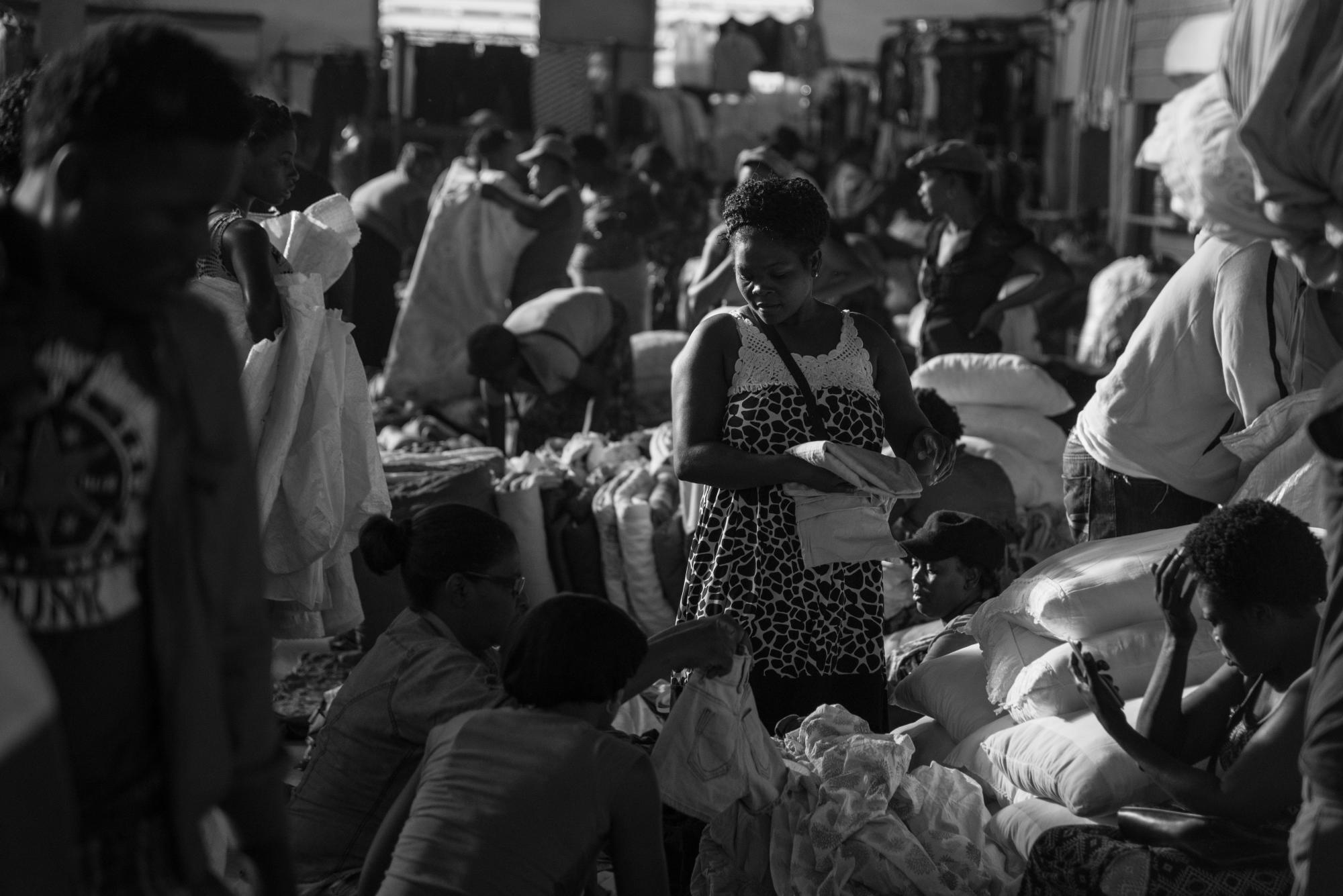 Una haitiana vende sábanas usadas y nuevas.