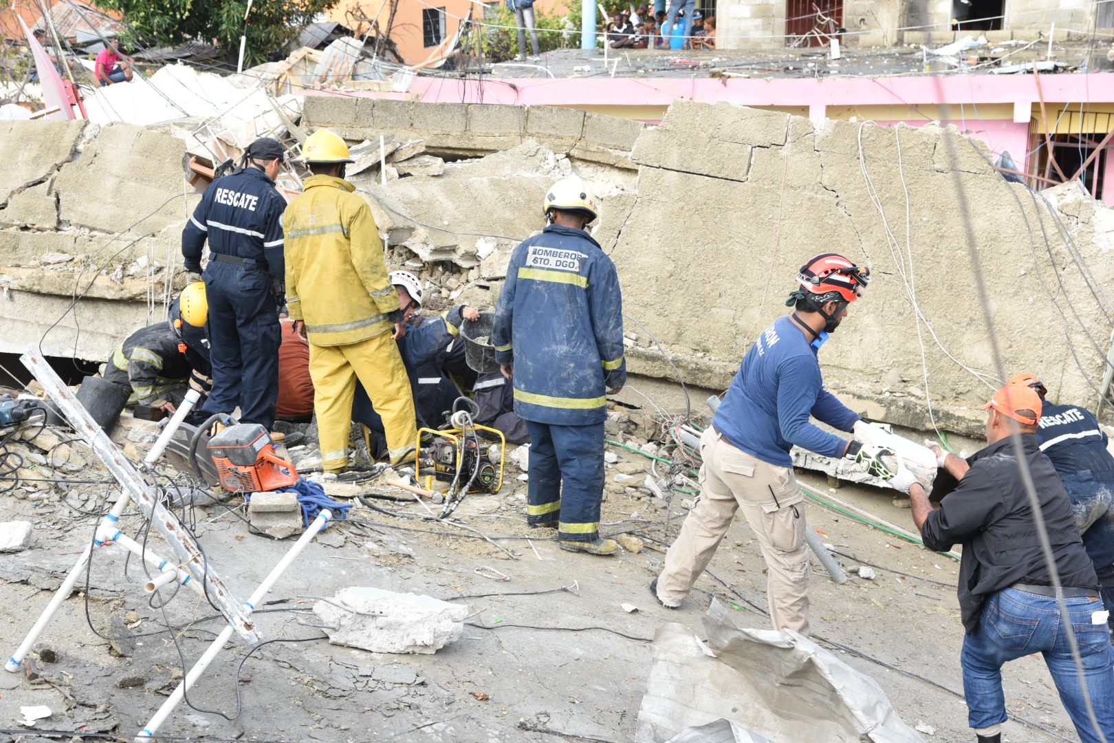 Miembros del equipo de rescate del Cuerpo de Bomberos del Distrito Nacional y de la Defensa Civil mientras remueven los escombros de las viviendas que se desplomaron producto de la explosión 