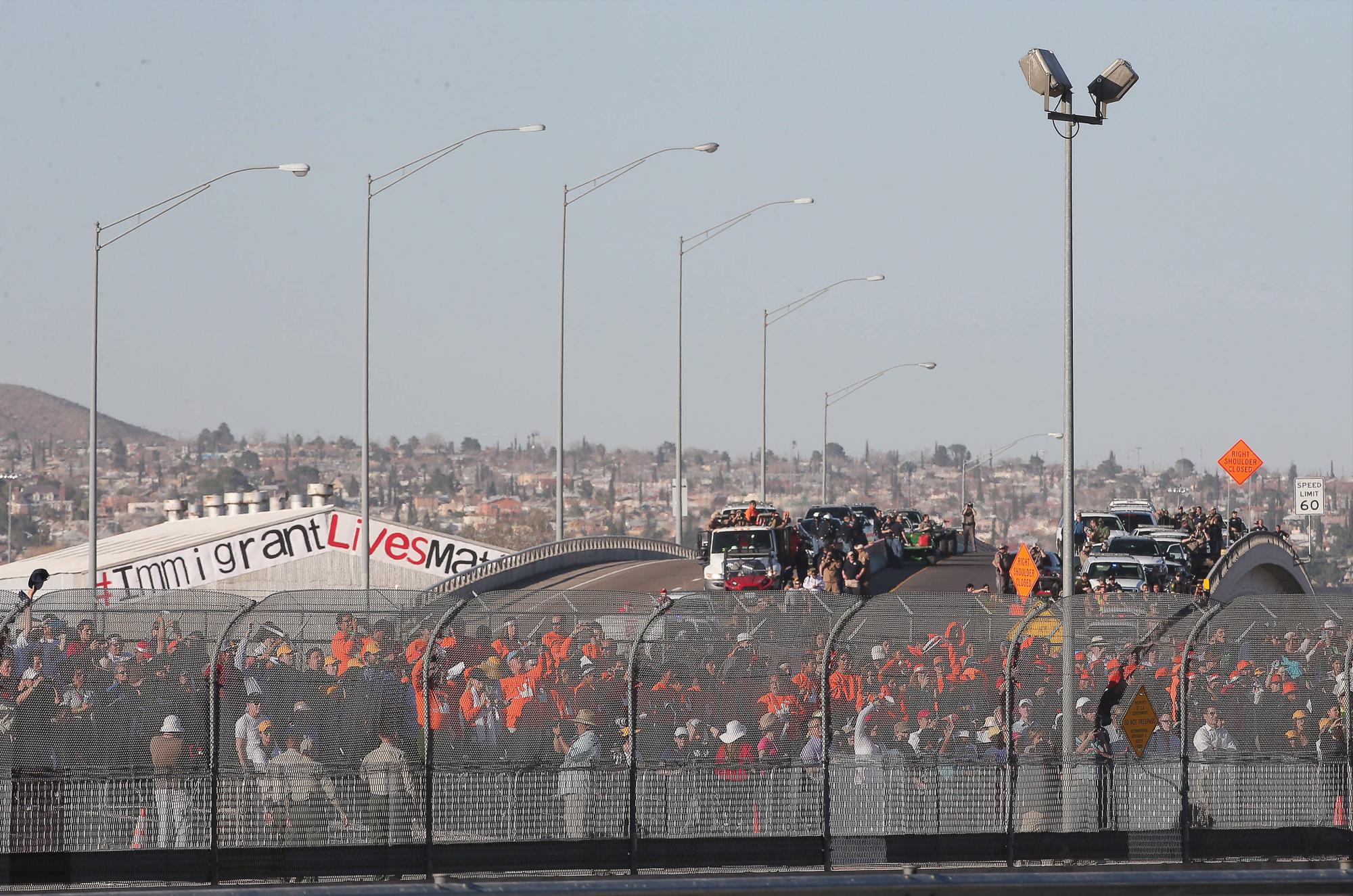 Personas observan al papa Francisco desde el lado estadounidense de la frontera durante una corta parada.