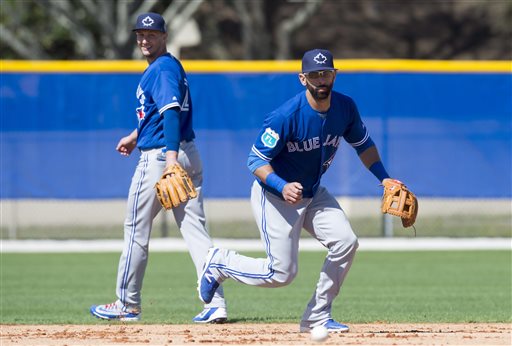 José Bautista toma rodados delante del torpedero Troy Tulowitzki en el complejo de los Azulejos en Dunedin, Florida.