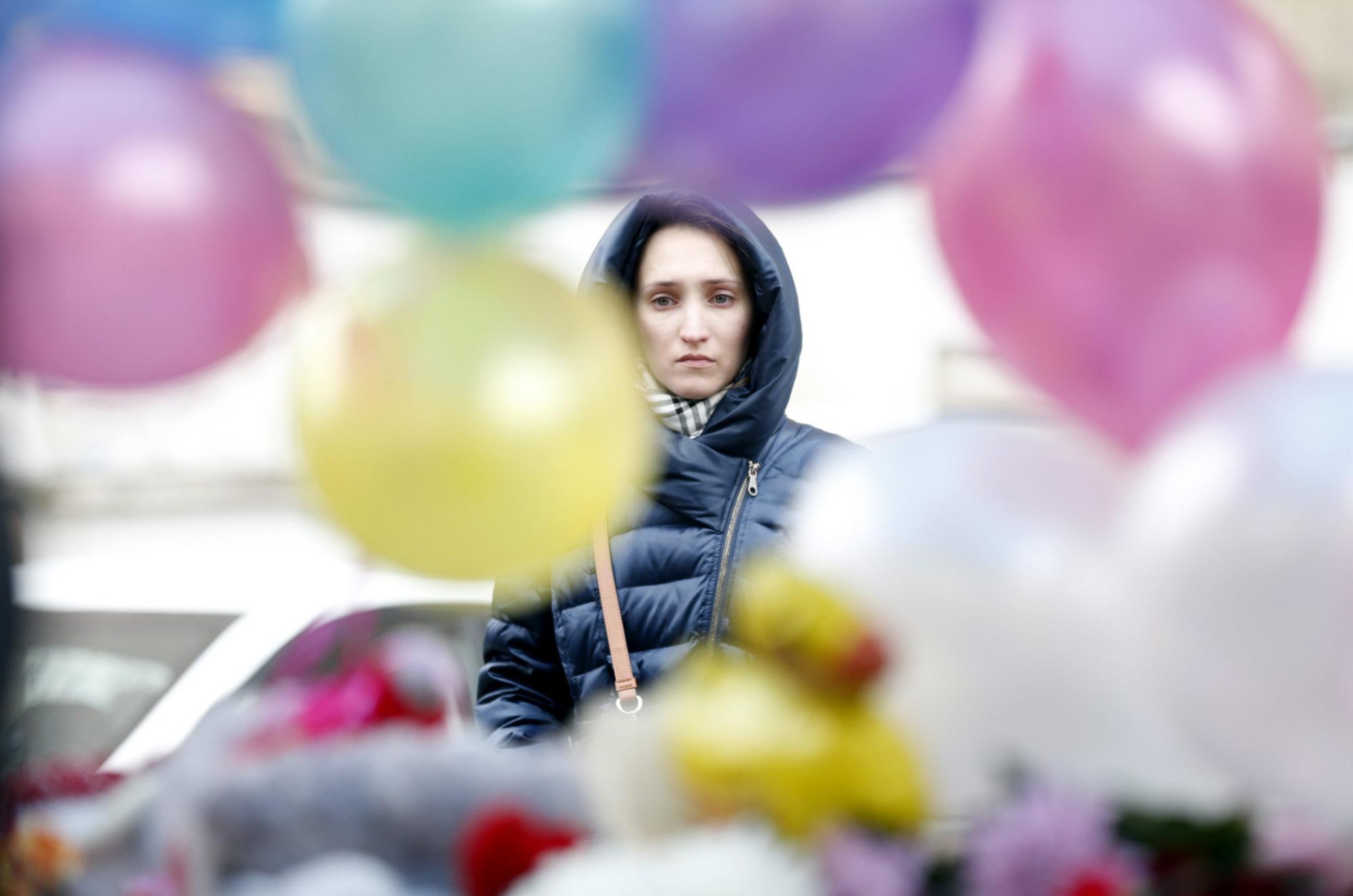 Una mujer se detiene ante los globos de colores colocados a la entrada de la estación de metro de Oktiabrskoye Pole donde una mujer fue detenida ayer tras pasear con la cabeza decapitada de una niña de cuatro años. 
