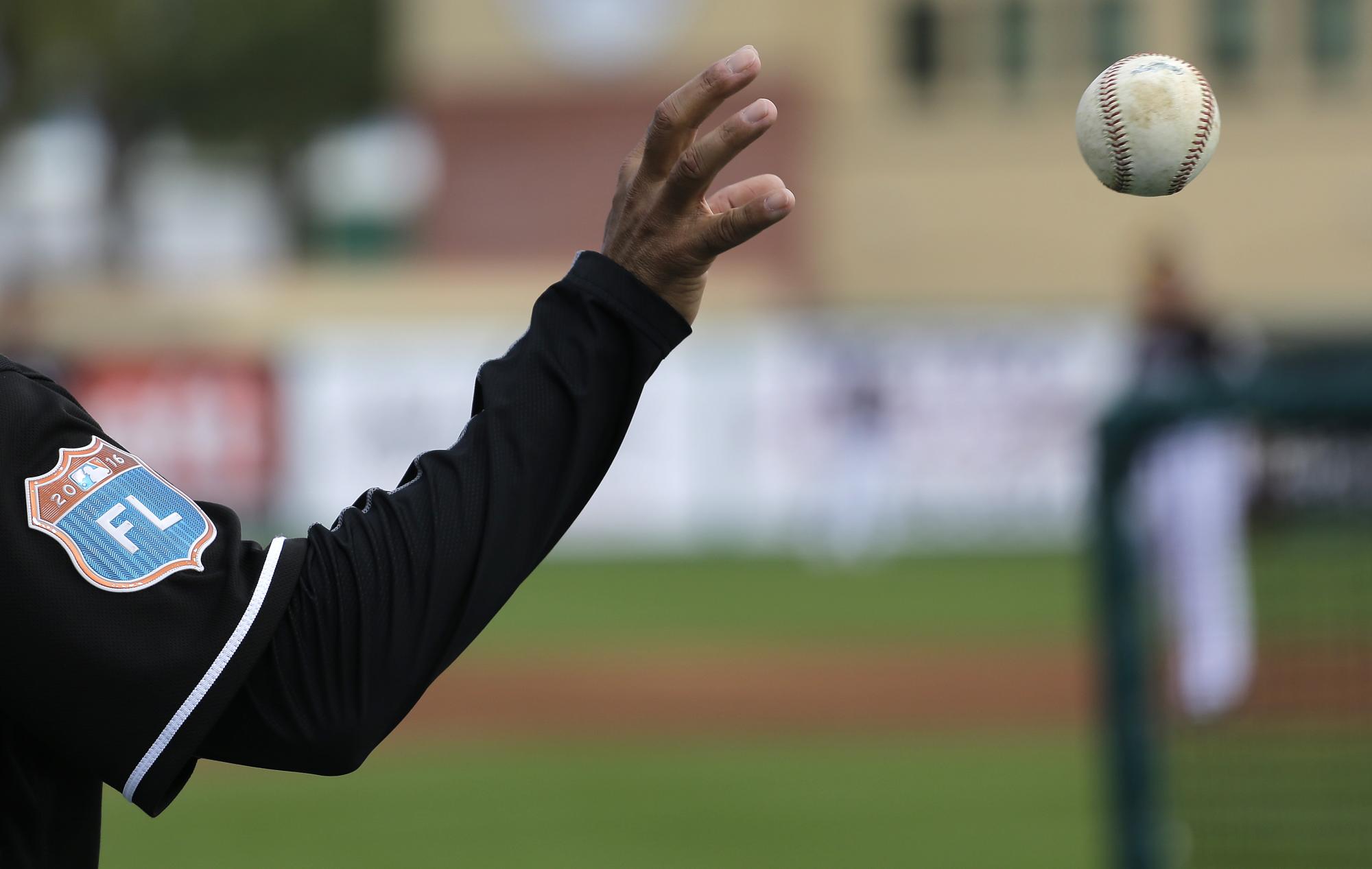 Un miembro de los Marlins de Florida recibe una de tantas bolas durante una práctica de bateo, antes de enfrentar a los Yanquis.