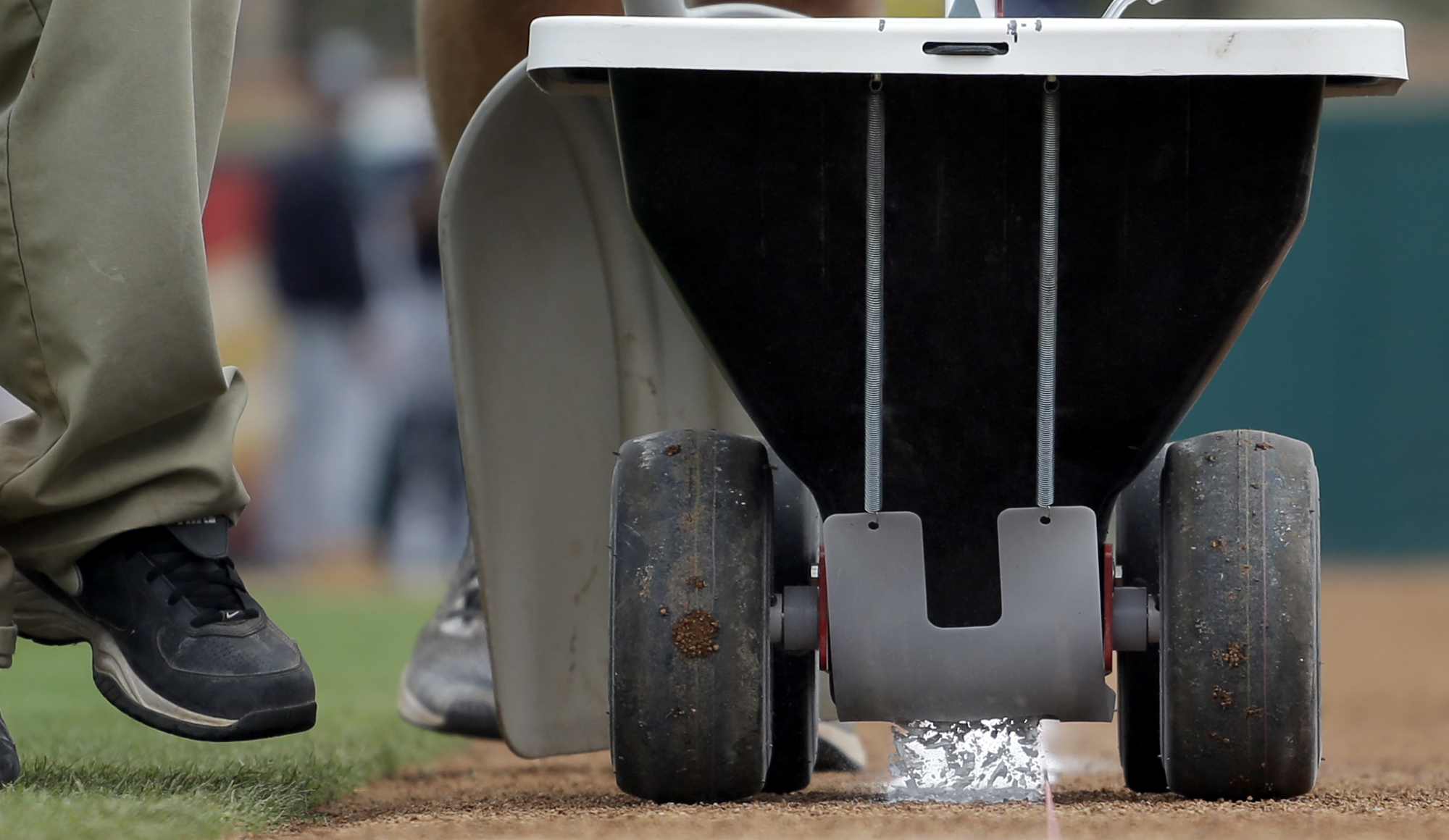 El carrito con el que se coloca la cal en el estadio, es maniobrado por un empleado del estadio Roger Dean en Jupiter, Florida, donde jugaron Yanquis y Marlins.