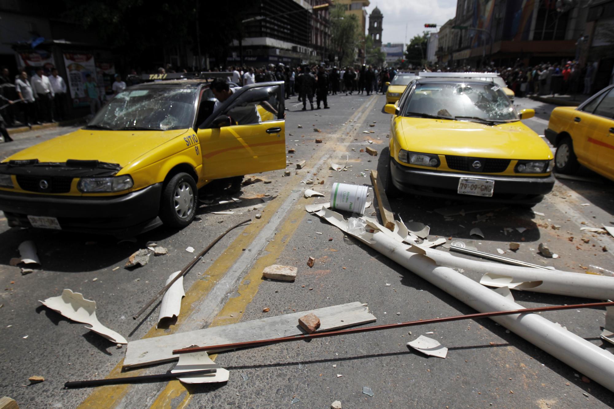 Vista de taxis afectados por enfrentamientos entre y comerciantes en Guadalajara hoy, martes 8 de marzo de 2016, tras una protesta contra el sistema de transporte ejecutivo Uber y en contra de las políticas del Gobierno al mismo tema. 