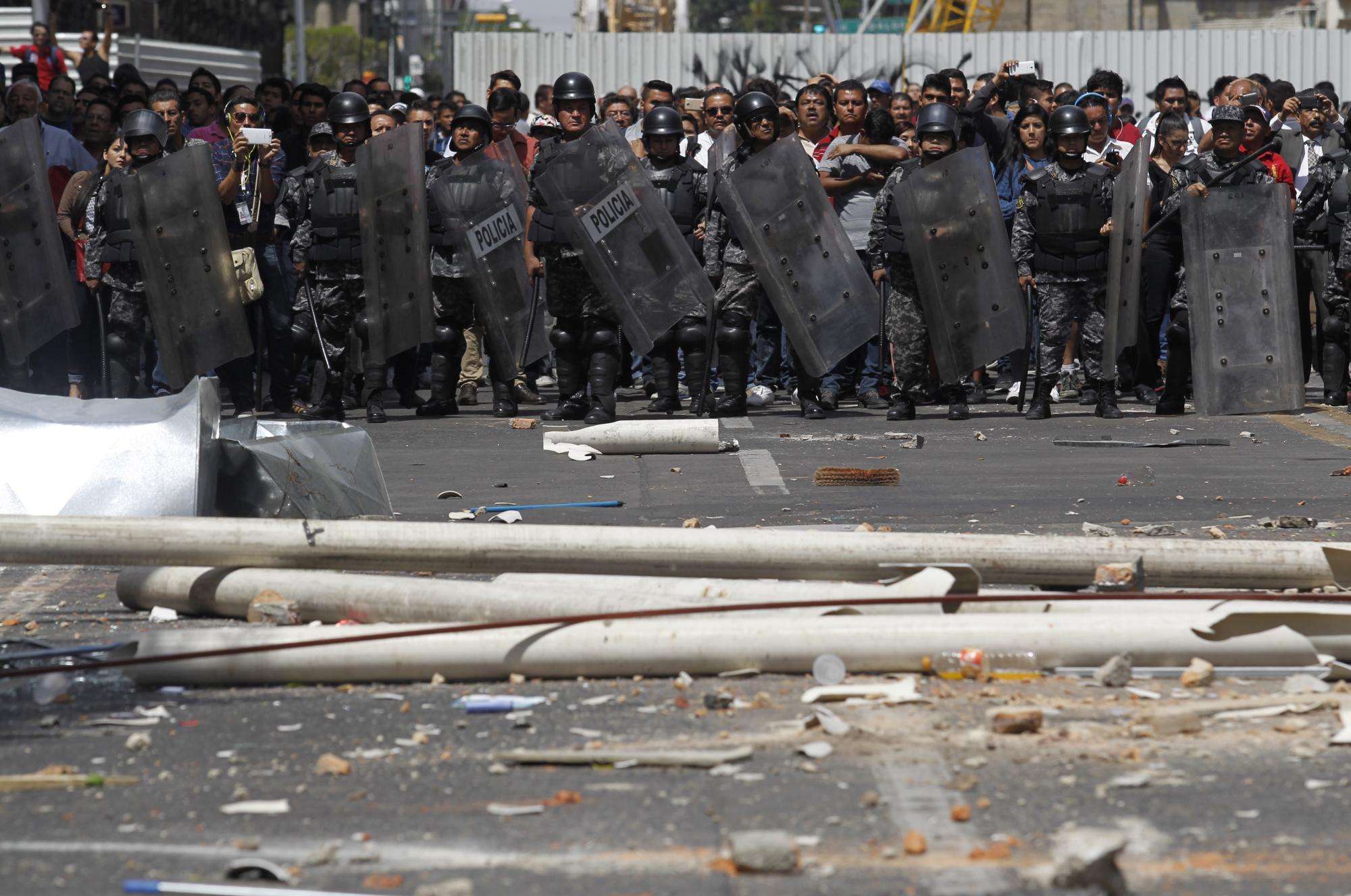 Policías arriban al lugar en el que taxistas se enfrentan con comerciantes en Guadalajara hoy, martes 8 de marzo de 2016, tras una protesta contra el sistema de transporte ejecutivo Uber.