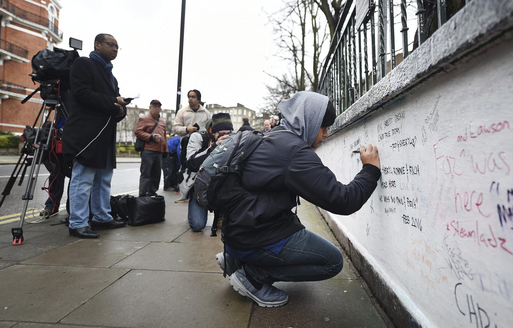 Un hombre escribe un mensaje de agradecimiento al exproductor de los Beatles George Martin en un muro junto a los estudios Abbey Road en Londres (Reino Unido) hoy, 9 de marzo de 2016.  