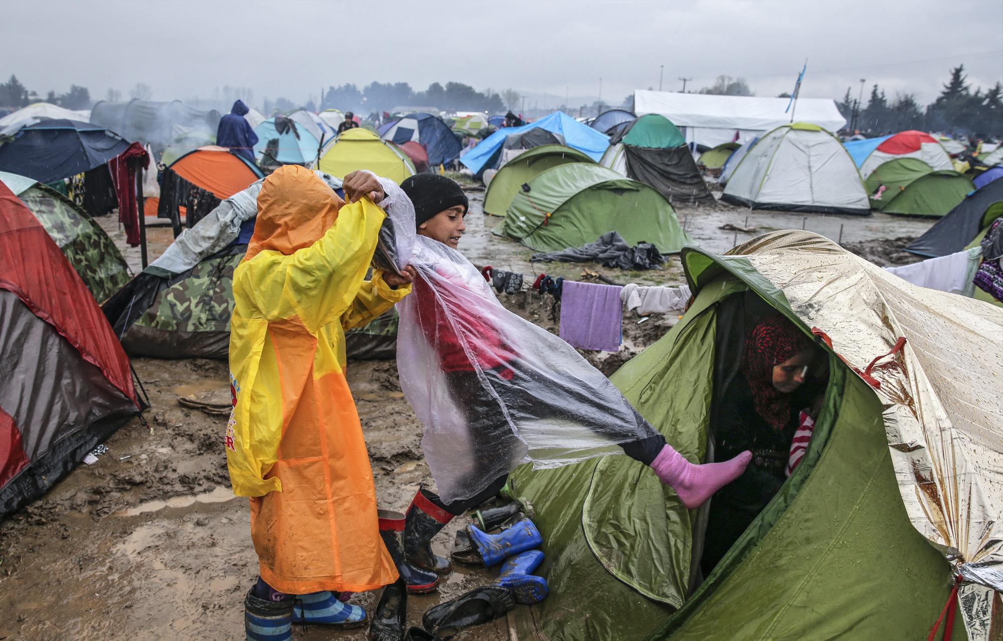 Un niño se resguarda de la lluvia en su tienda de campaña en el campamento de refugiados, en la frontera entre Grecia y Macedonia, cerca de Idomeni, Grecia. 