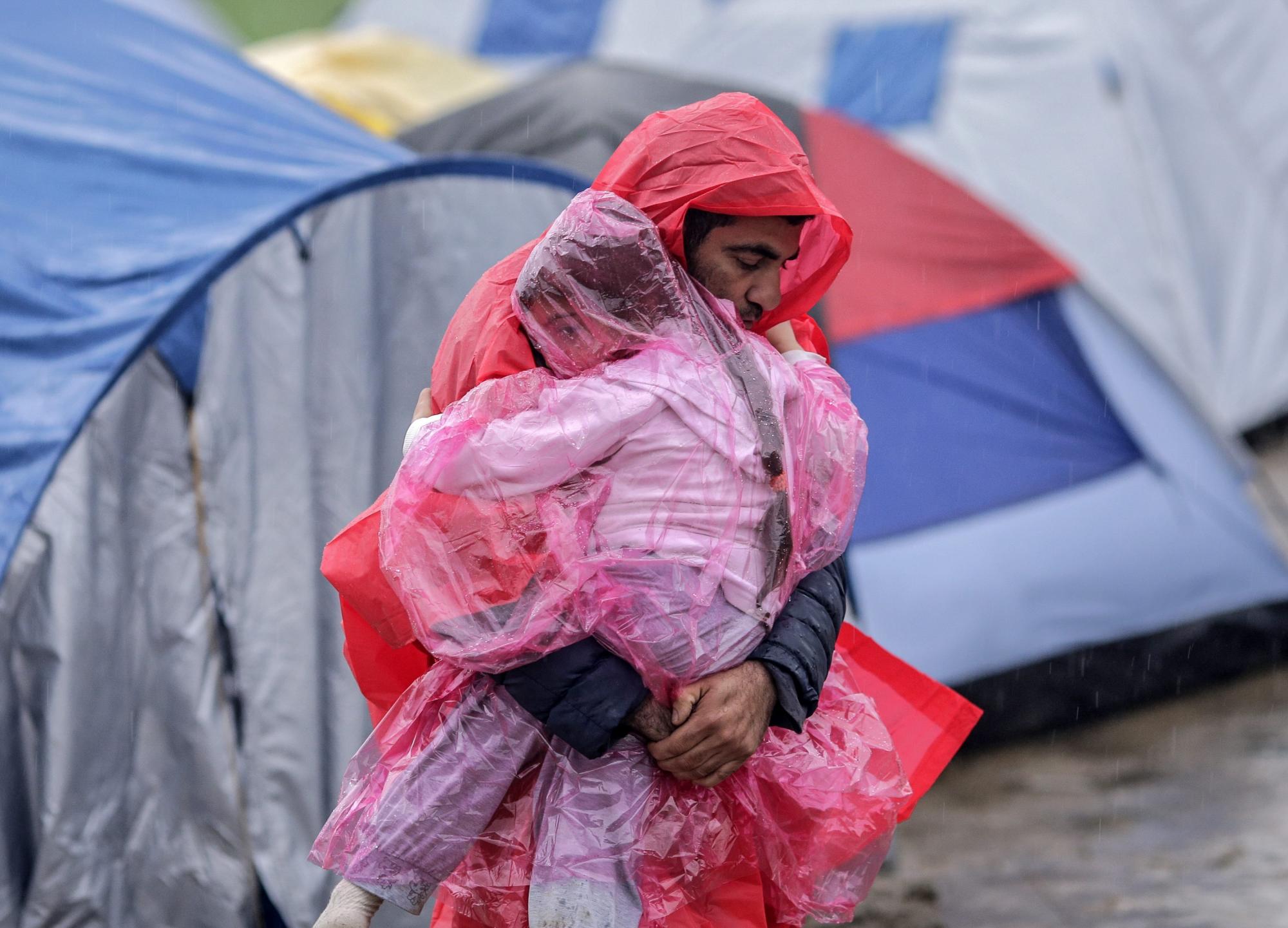Un refugiado cubre a su hijo en un campamento de refugiados, en la frontera entre Grecia y Macedonia, cerca de Idomeni, Grecia. 