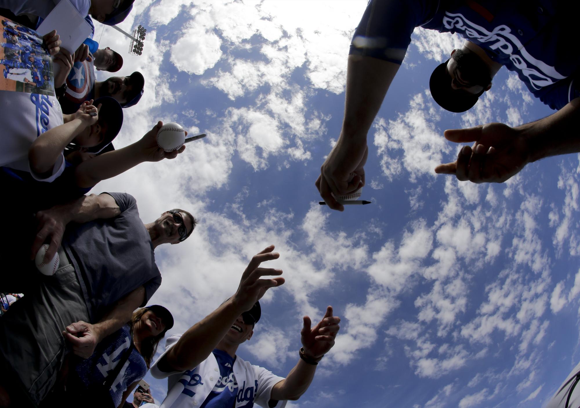El “utility” Alex Hassan, de los Dodgers de Los Angeles, firma autógrafo antes de un partido contra los Gigantes de San Francisco en Scottsdale, Arizona.