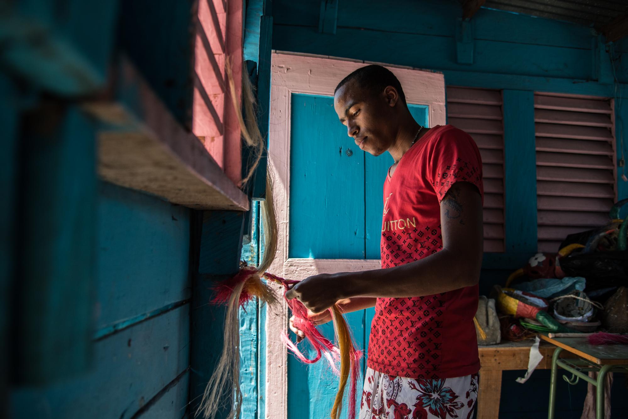 Un joven trabaja en la elaboración de fuetes y máscaras. 