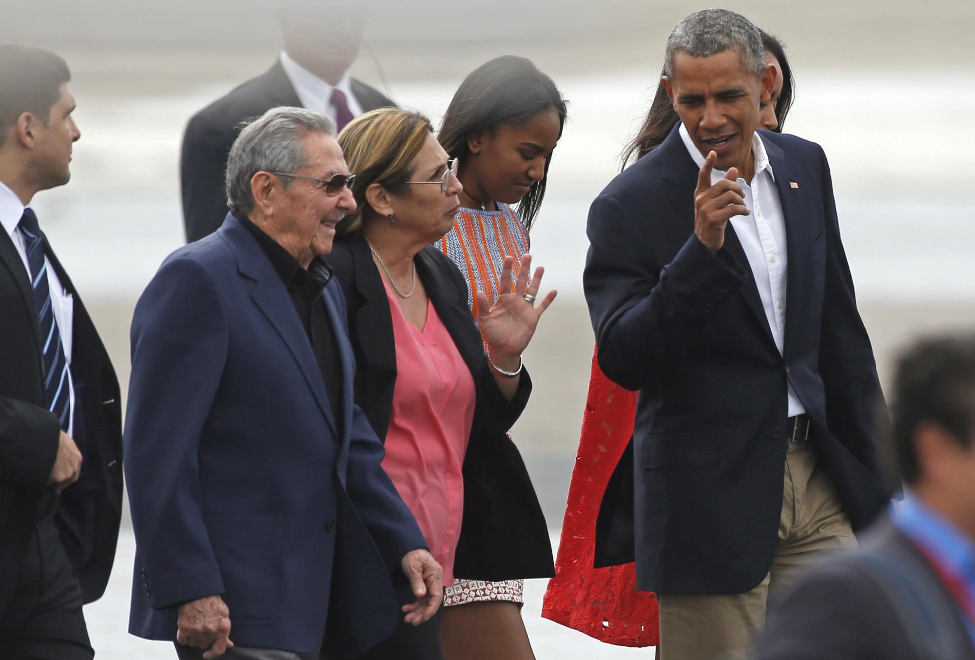 El presidente Barack Obama, a la derecha, conversa con el presidente de Cuba, Raúl Castro, a la izquierda, antes de abordar el avión presidencial en su camino a la Argentina, en La Habana, Cuba, Martes, 22 de marzo de 2016. Detrás están las hijas de Obama Sasha, segundo desde la derecha, y Malia , parcialmente cubierta. La visita de Obama fue un momento culminante en su oferta y en negrita de Castro para restablecer los lazos diplomáticos después de una congelación de medio siglo. 