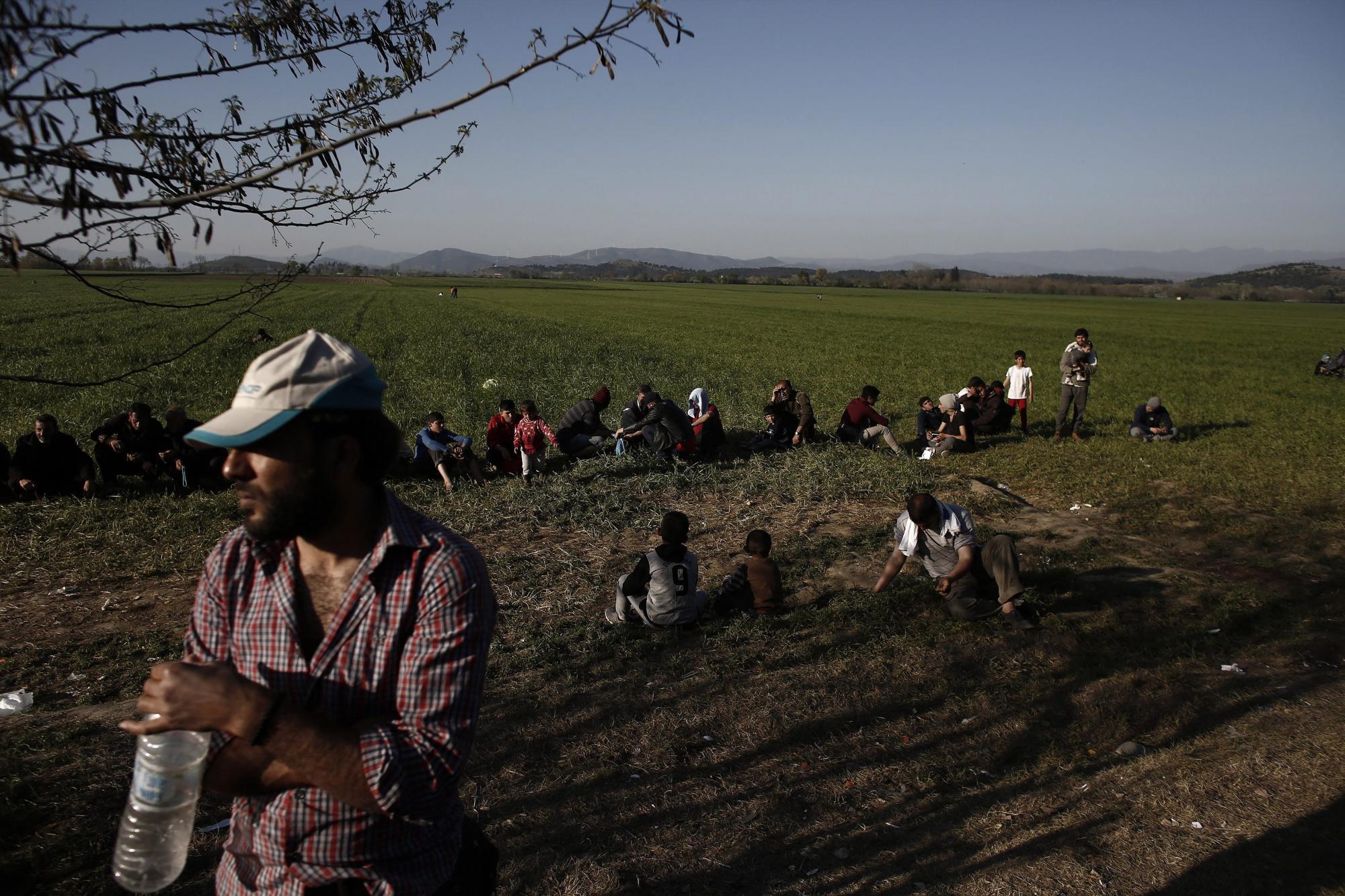 Refugiados esperan para recibir comida mientras hoy, jueves 31 de marzo de 2016, en un campo de refugiados en Idomeni, región fronteriza entre Grecia y Macedonia. 