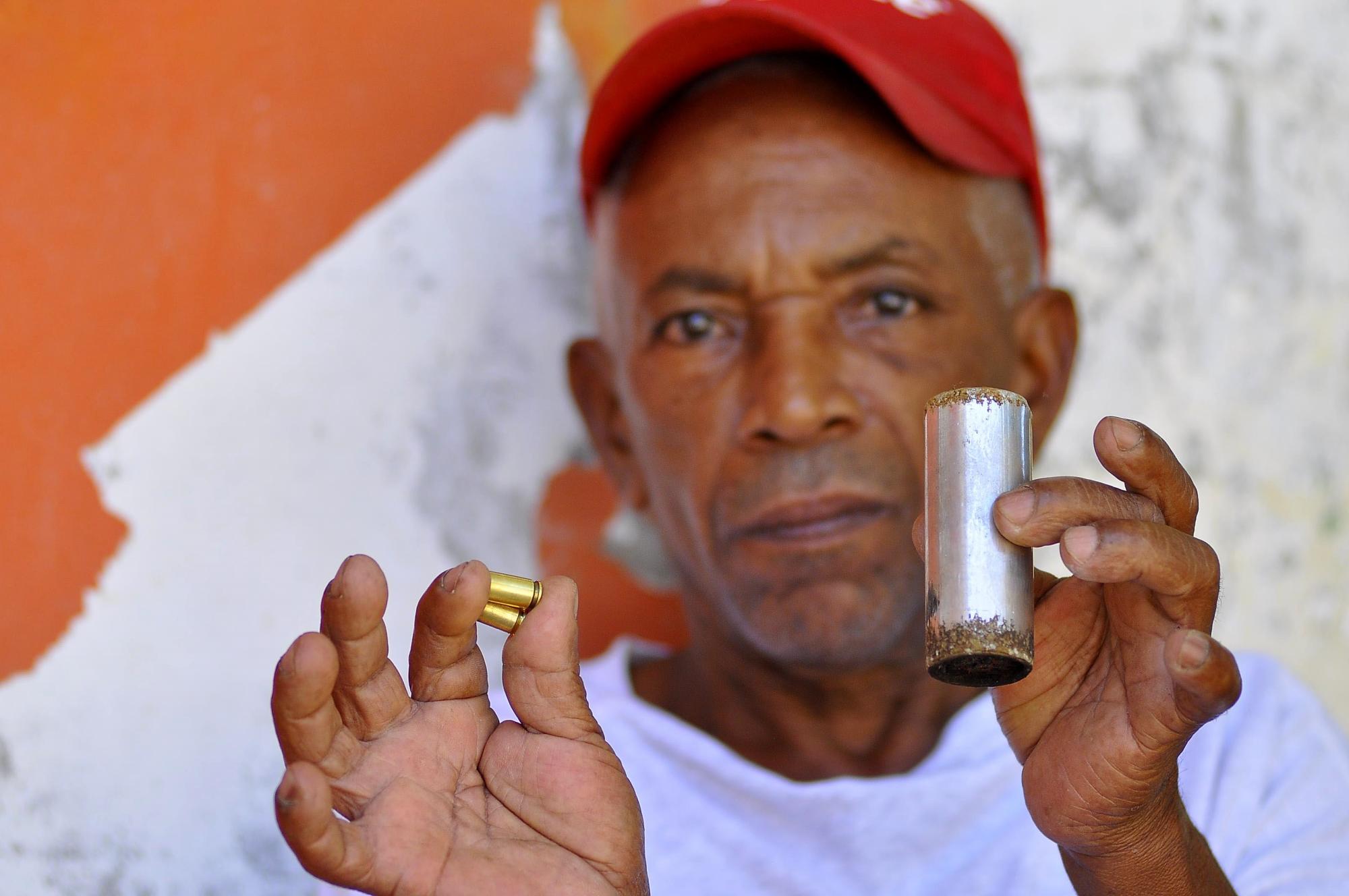 Un hombre muestra las balas y el cilindro de una granada que fue lanzada durante la protesta