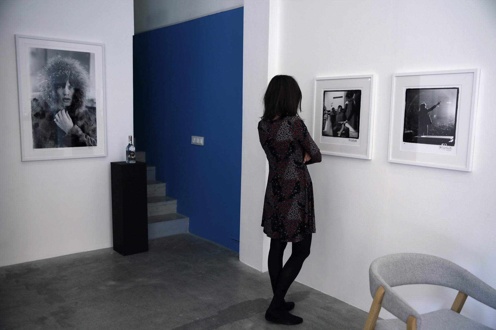 Una mujer observa una fotografía de la exposición Breaking Stones.