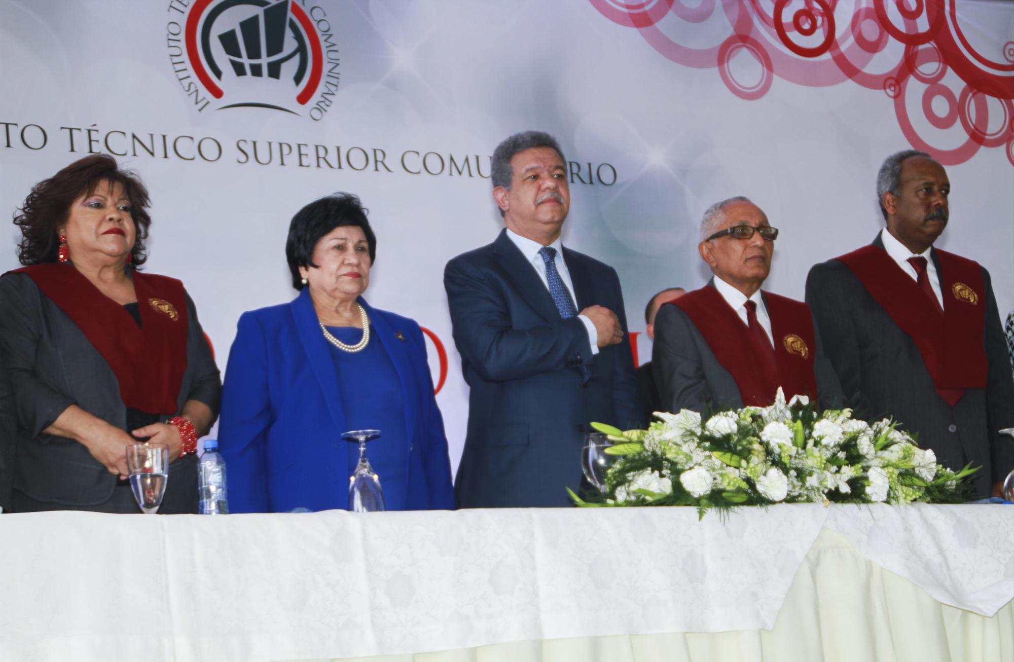 Los integrantes de la mesa de honor de pie, durante el himno nacional 
