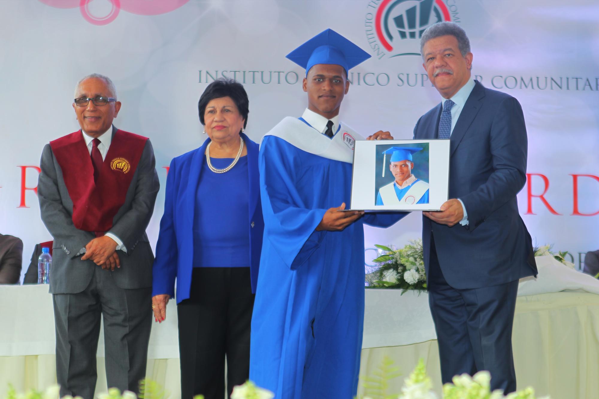 Leonel Fernández, le entrega su diploma a uno de los nuevos técnicos  