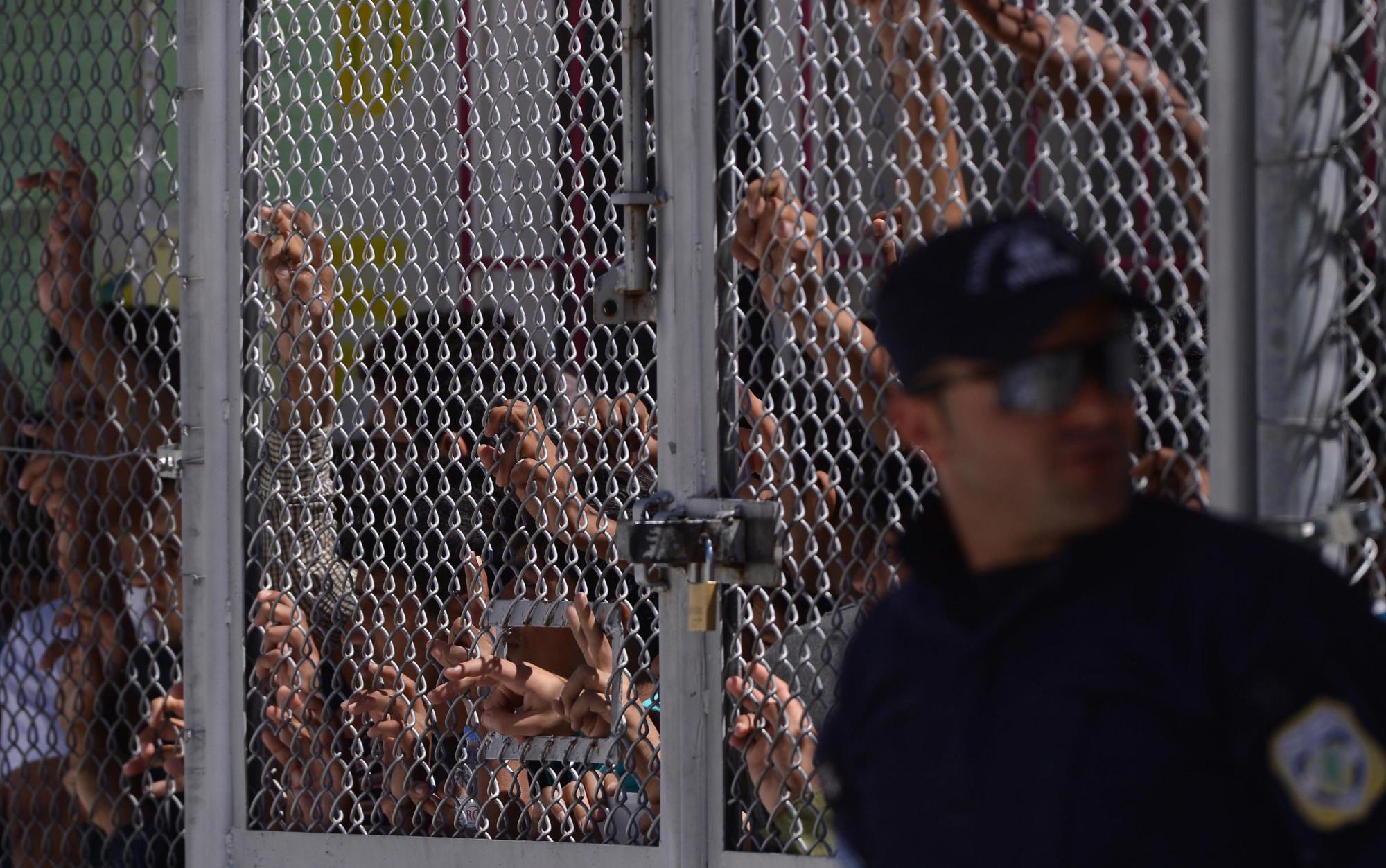 Migrantes y refugiados están detrás de una valla durante la visita de Francisco en el Moria hoy, 16 de abril de 2016.