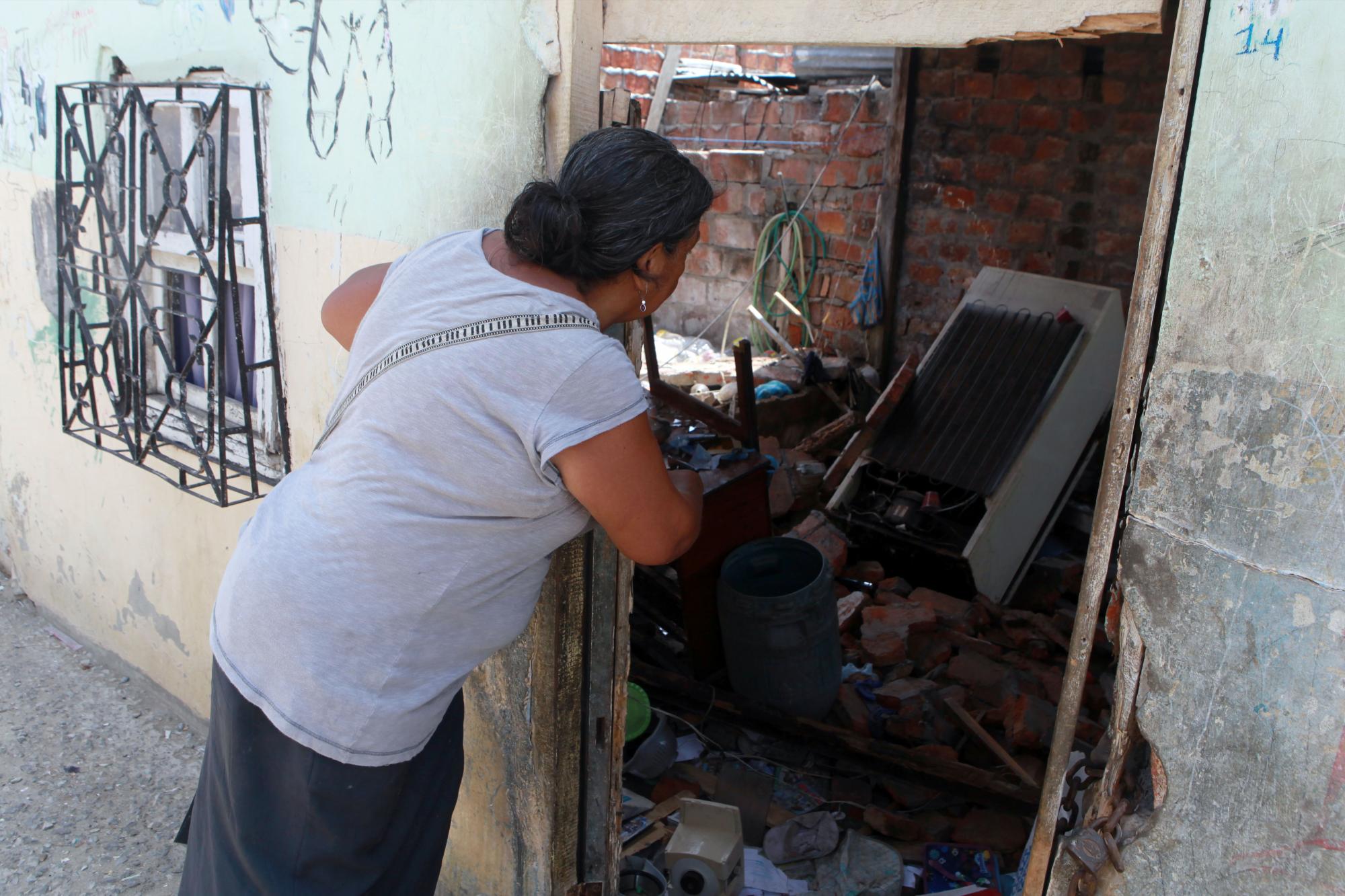 Una mujer observa el estado de su casa colapsada por el terremoto hoy, viernes 22 de abril de 2016, en el puerto de Manta.