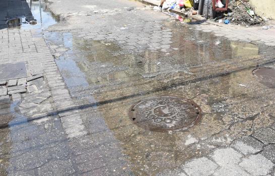 Turistas tienen que saltar hoyo con agua cloacal en la Zona Colonial