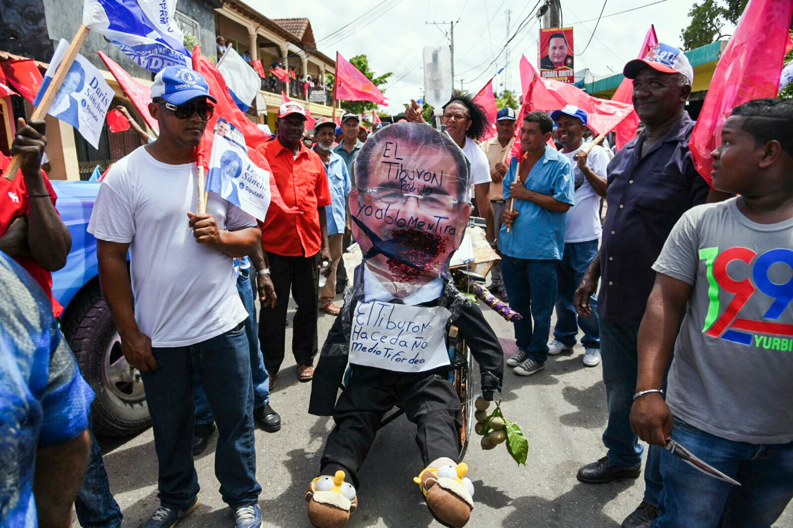 Seguidores del perremeísta Luis Abinader observan un muñeco confeccionado para burlarse de su contrario, el candidato-presidente Danilo Medina, durante un caravaneo en la provincia Puerto Plata.