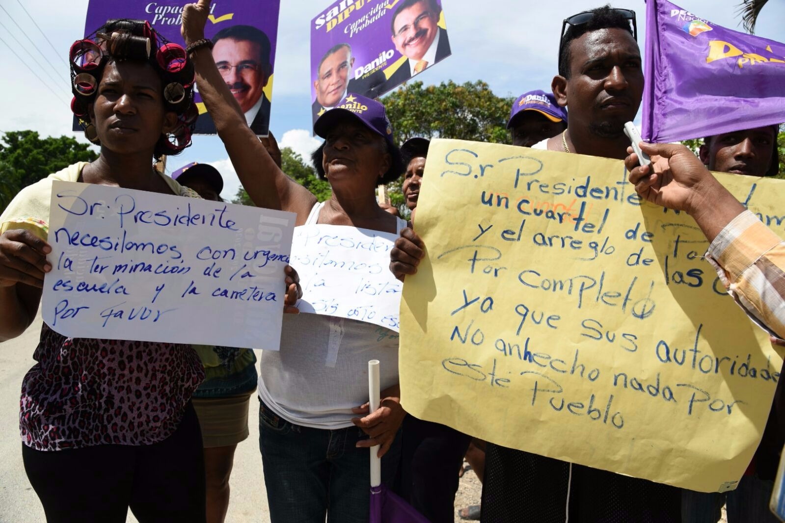  Moradores del Batey La Paloma muestran letreros como en reclamo de la terminación de una escuela cuya construcción está paralizada desde hace meses, según dijeron.