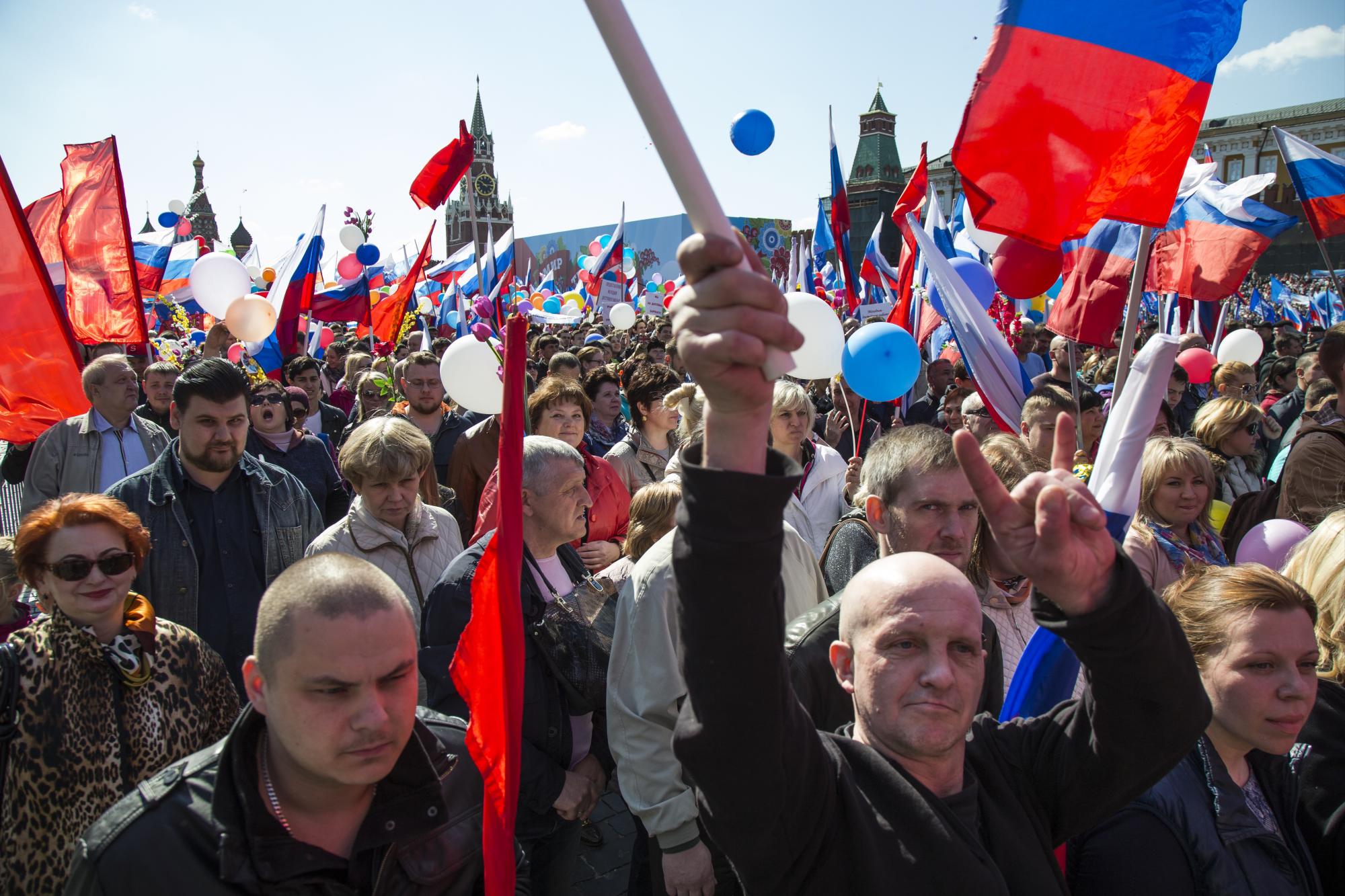 RUSIA. Rusos ondean banderas y corean lemas en su camino hacia la Plaza Roja de Moscú con motivo del Primero de Mayo.