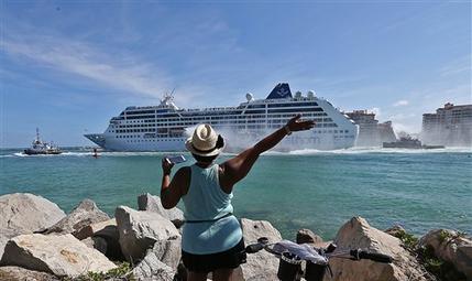 Una mujer despide al buque Adonia que parte del puerto en Miami rumbo a Cuba, el domingo 1 de mayo de 2016. 