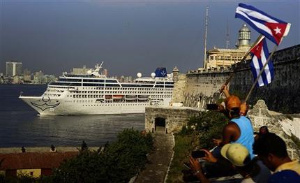 Varias personas ondean banderas cubanas para dar la bienvenida a los pasajeros del crucero de Carnival Adonia mientras llega desde Miami a La Habana, Cuba, el lunes 2 de mayo de 2016.
