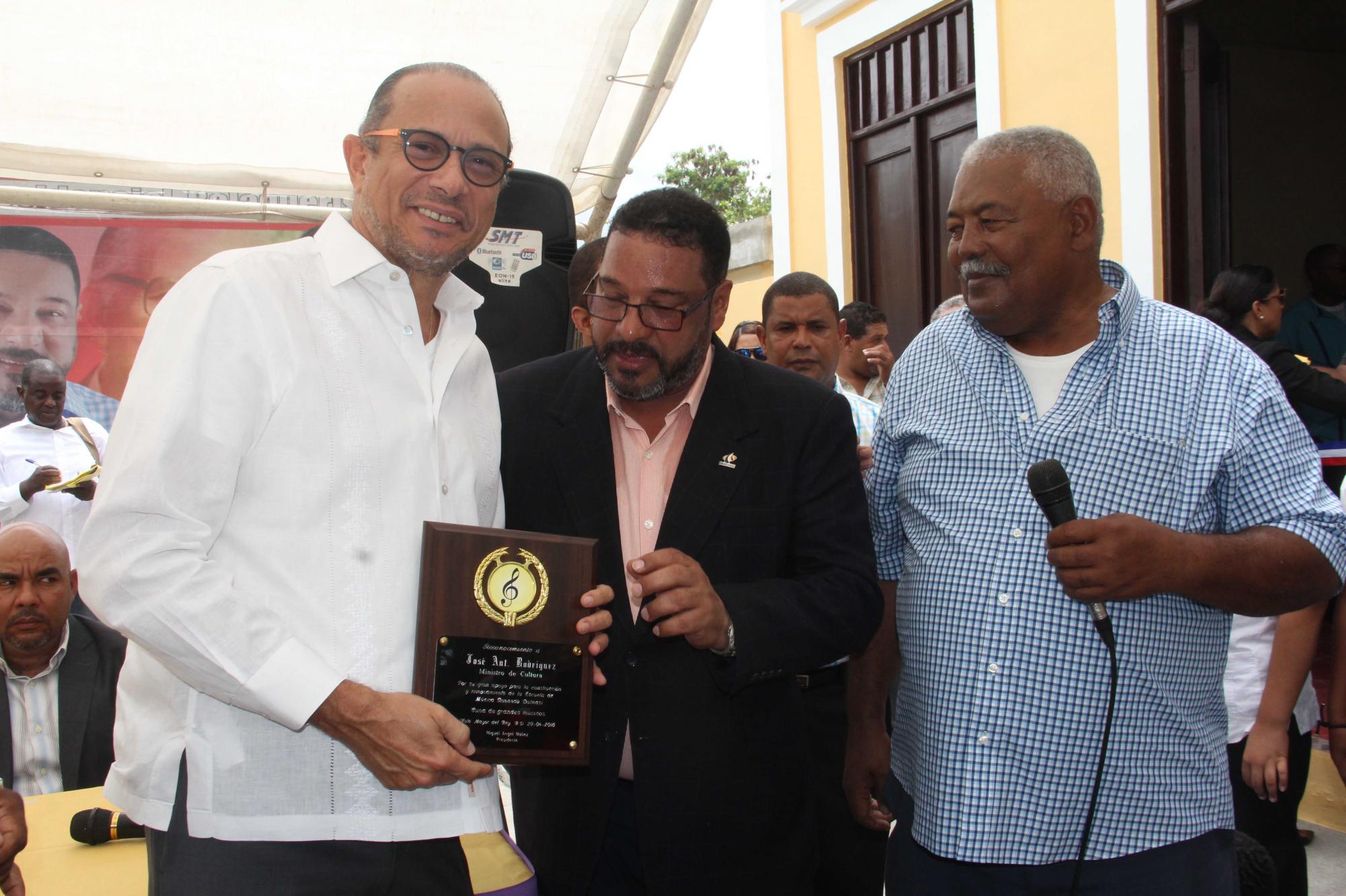 El alcalde Reynato de Jesús Cruz  Tineo, entrega al  ministro de Cultura, cantautor José Antonio Rodríguez, una placa de reconocimiento. 