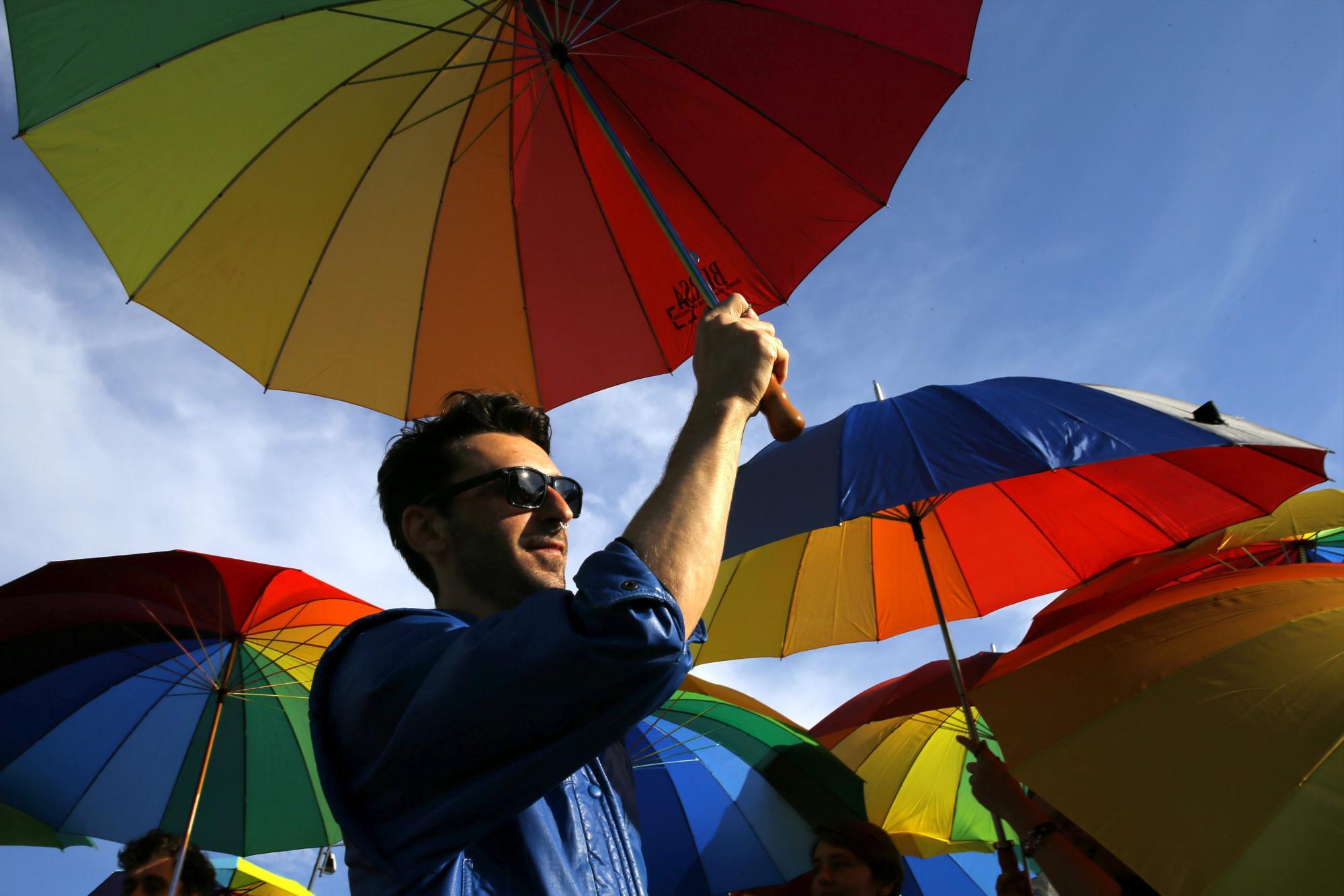  (RUMANÍA)- Varias personas sostienen paraguas con los colores del arco iris durante un flashmob por los derechos de la comunidad homosexual, organizado frente al Parlamento en Bucarest, Rumanía, hoy, 17 de mayo de 2016.