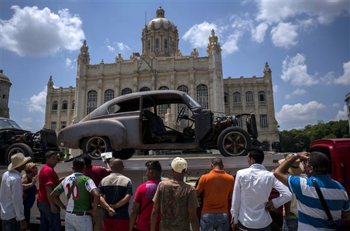 Curiosos observan vehículos a ser usados en la filmación de la nueva entrega de la película Rápidos y furiosos, los cuales están estacionados frente al Museo de la Revolución de La Habana el 22 de abril del 2016. 