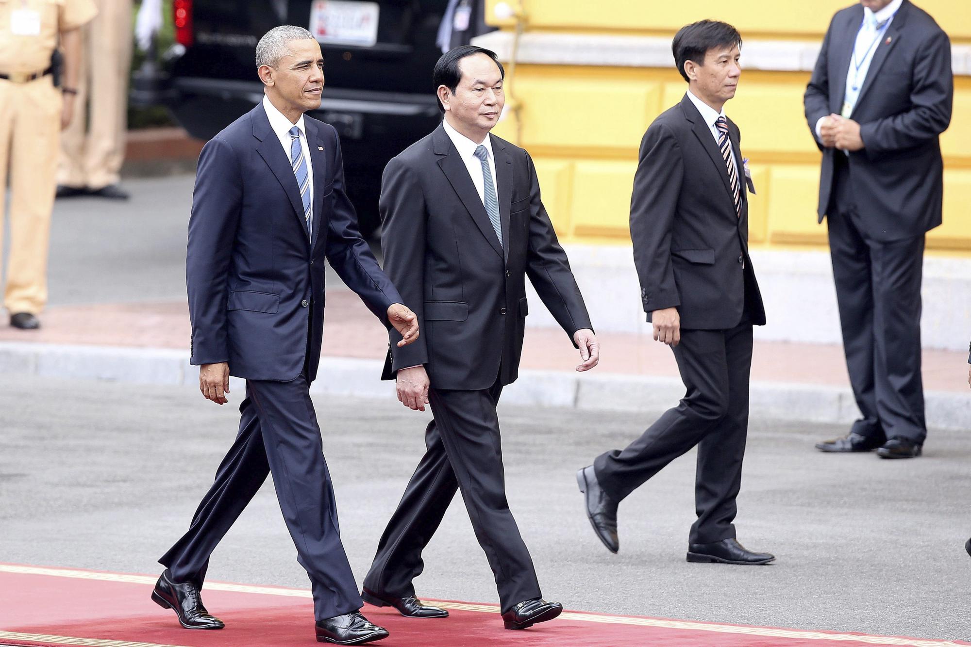 El presidente estadounidense, Barack Obama (izq), y su homólogo vietnamita, Tran Dai Quang (c), pasan revista a la guardia de honor en el Palacio Presidencial en Hanoi. 