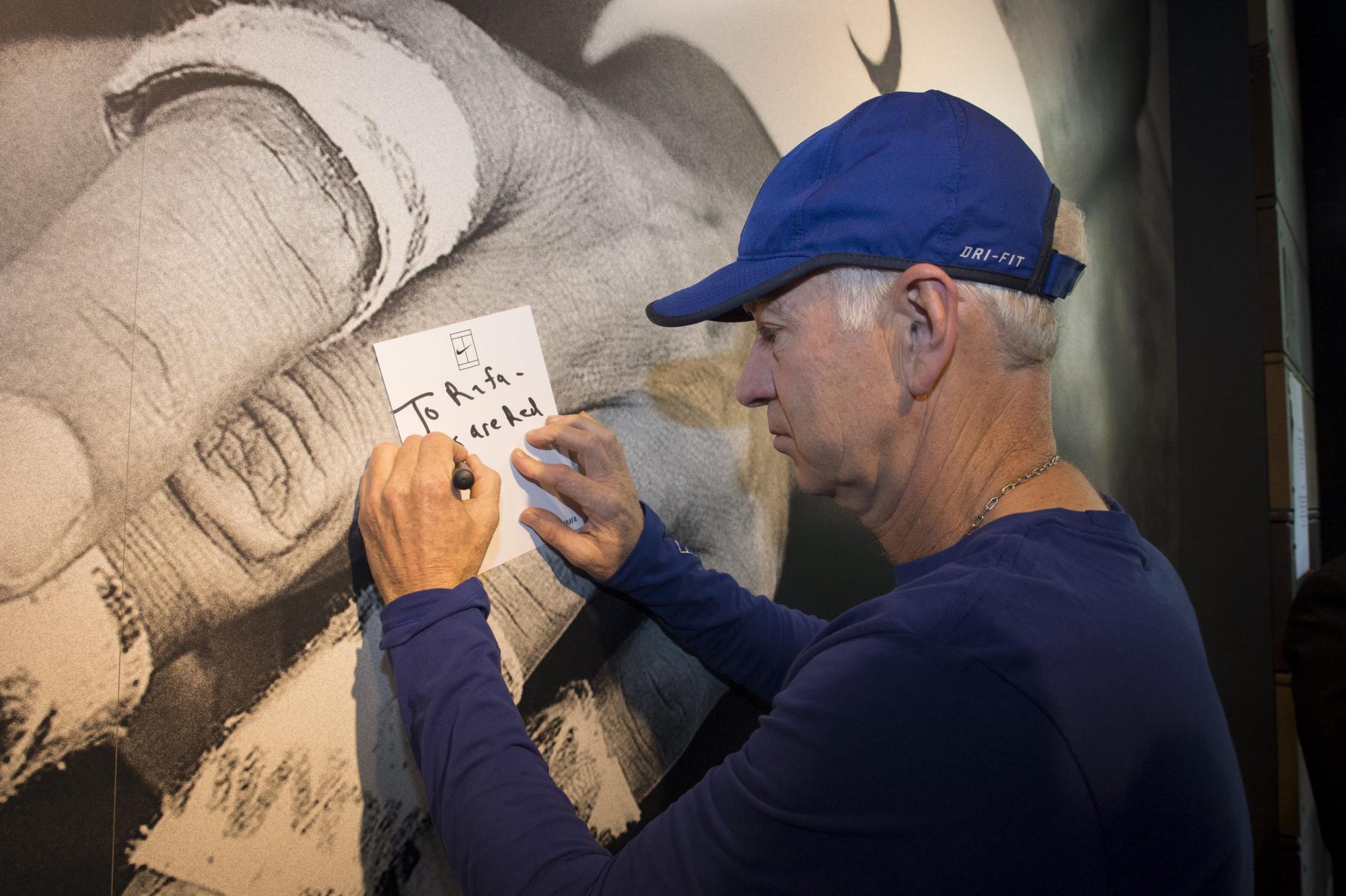 La leyenda del tenis estadounidense John McEnroe escribe un mensaje de apoyo a Rafael Nadal en el muro que Nike ha colgado en París (Francia) para que jugadores profesionales, amateurs y fans apoyen al tenista mallorquín durante Roland Garros.
