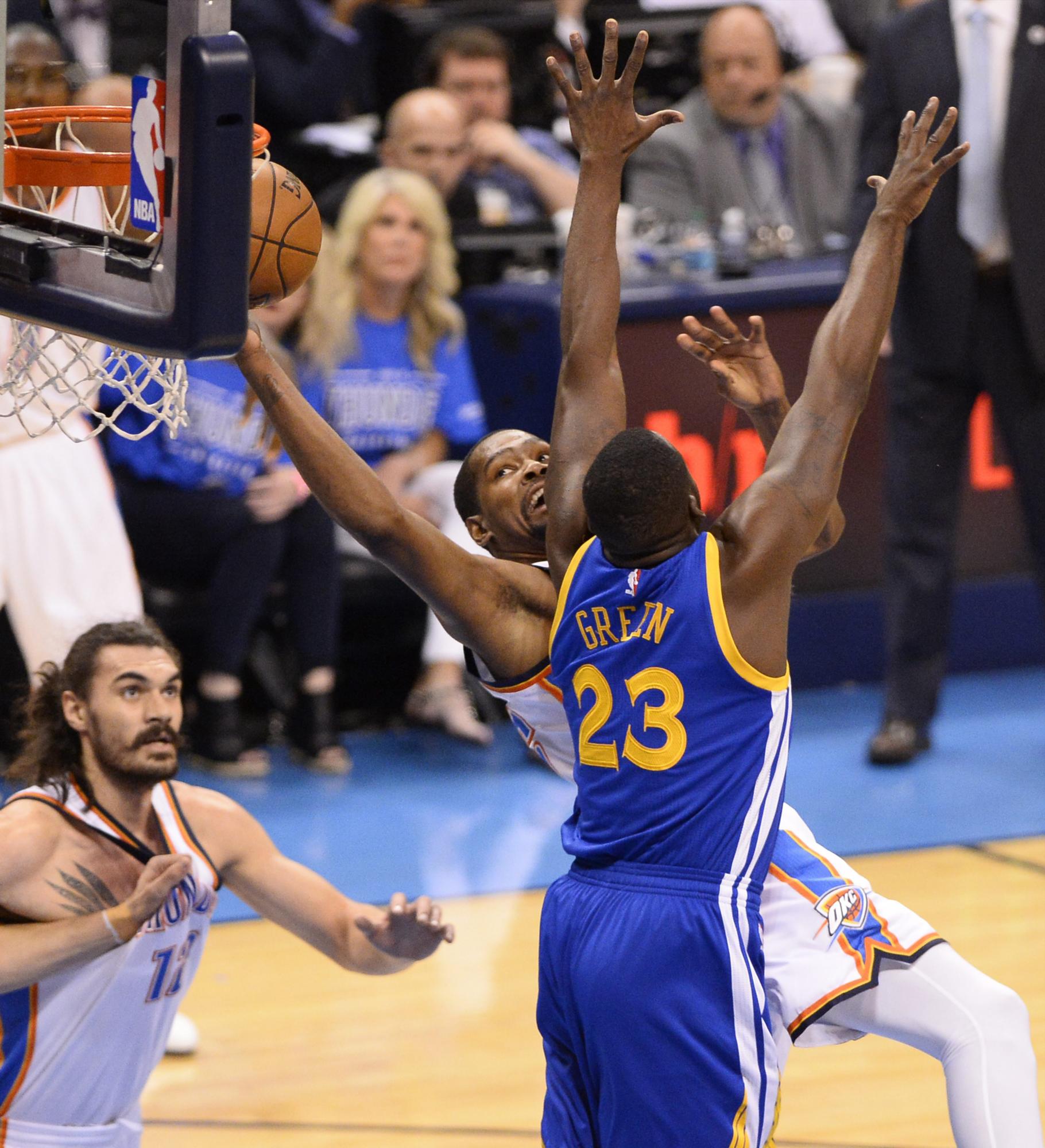 Draymond Green (derecha)  es bloqueado por Kevin Durant (centro) en el partido del sábado 28 de mayo del 2016 por la Conferencia Oeste de la NBA.