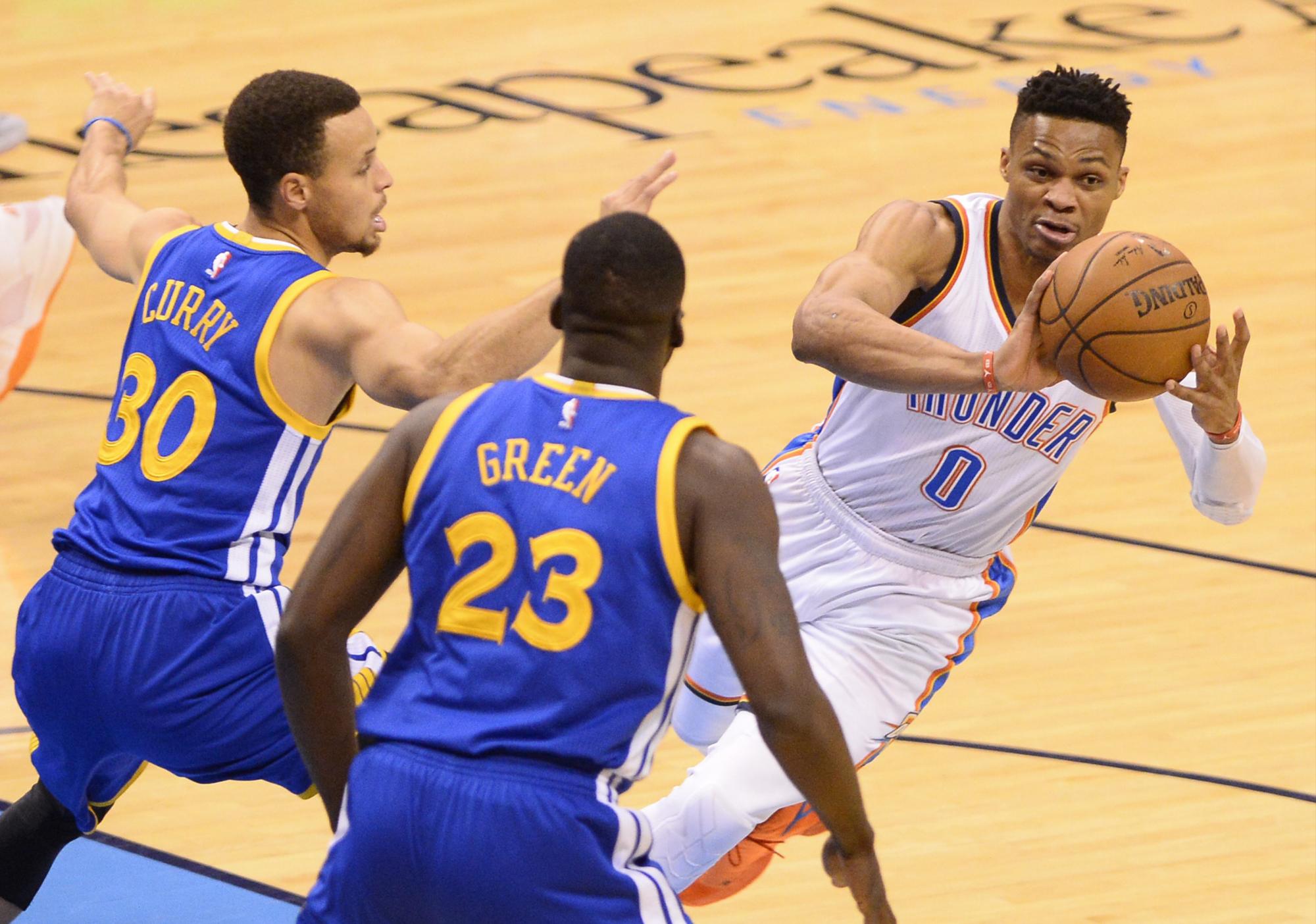 Stephen Curry –izq- y Draymond Green –c- acoralan a Russell Westbrook -der-, en el partido de la NBA por la Conferencia Oeste. 