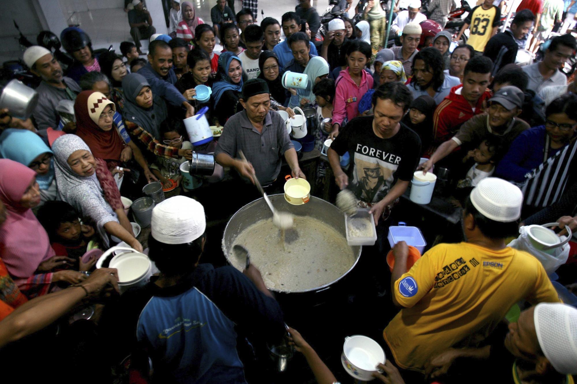 Ciudadanos musulmanes esperan su turno para obtener un bol de avena cocida en la mezquita Darussalam donde cientos de boles son repartidos cada día para terminar con su ayuno en la época de Ramadán en Solo, Indonesia, hoy 6 de junio de 2016. 