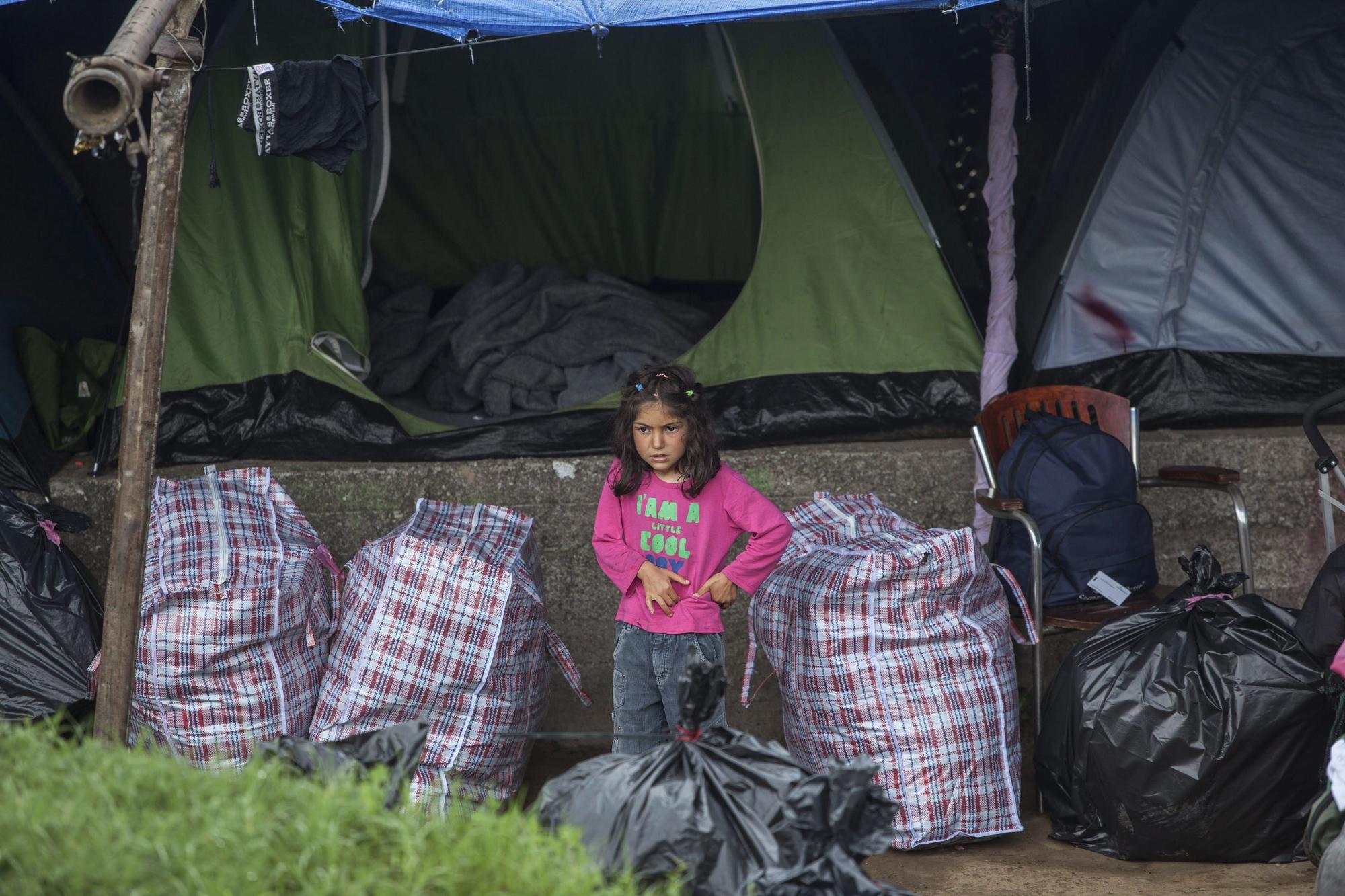 Una niña espera junto a su tienda a ser trasladada mientras la policía continúa con el desalojo del campo de refugiados improvisado en la localidad de Polykastro, próxima a Idomeni (Grecia)