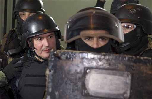 El exsecretario de Obras Públicas, José López, izquierda, sale escoltado por agentes desde una estación policial en las afueras de Buenos Aires, Argentina, el martes 14 de junio de 2016. 