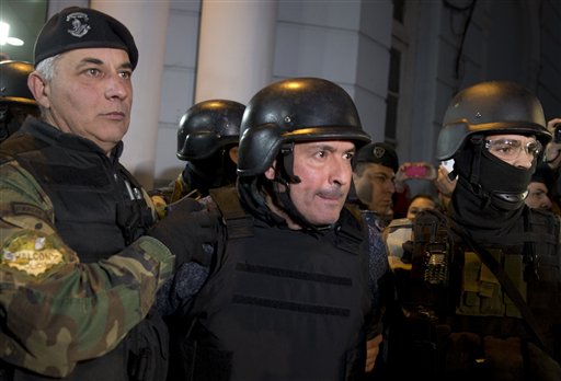 El exsecretario de Obras Públicas José López, centro, sale escoltado por agentes desde una estación policial en las afueras de Buenos Aires, Argentina, el martes 14 de junio de 2016.