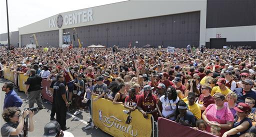 Una multitud espera el paso de los jugadores de los Cleveland Cavaliers a la ciudad. 