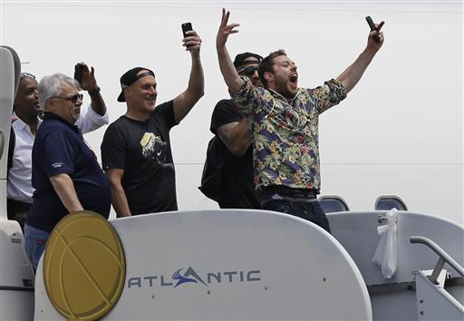 Matthew Dellavedova sonríe con varios compañeros al aterrizar en el aeropuerto de Cleveland.