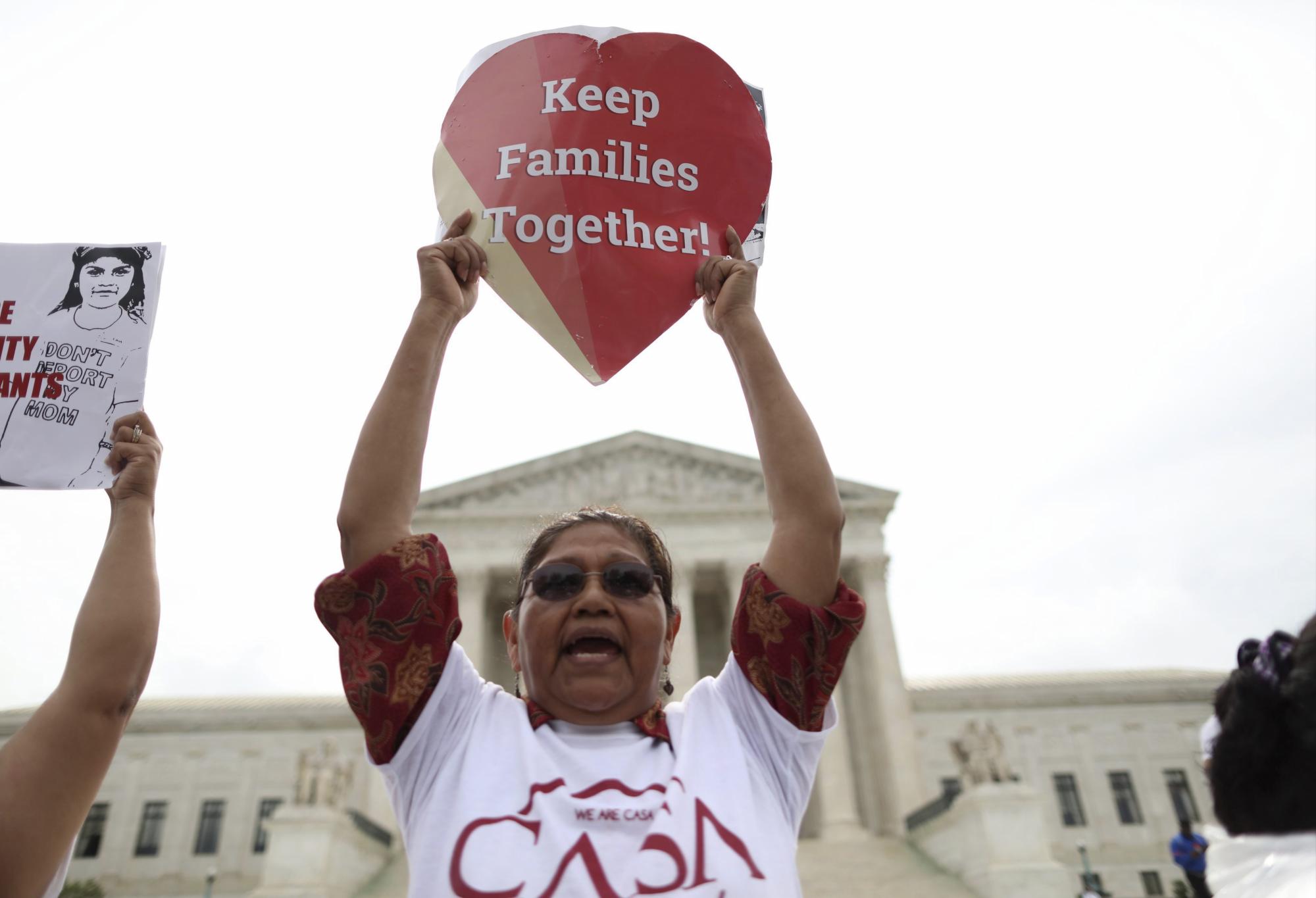 Ciudadana reacciona sosteniendo una pancarta con la consigna 'Keep Families Together' (Mantened las familias unidas) ante la decisión del Tribunal Supremos de Estados Unidos sobre las medidas migratorias del presidente estadounidense, Barack Obama, hoy, 23 de junio de 2016, en Washington DC.