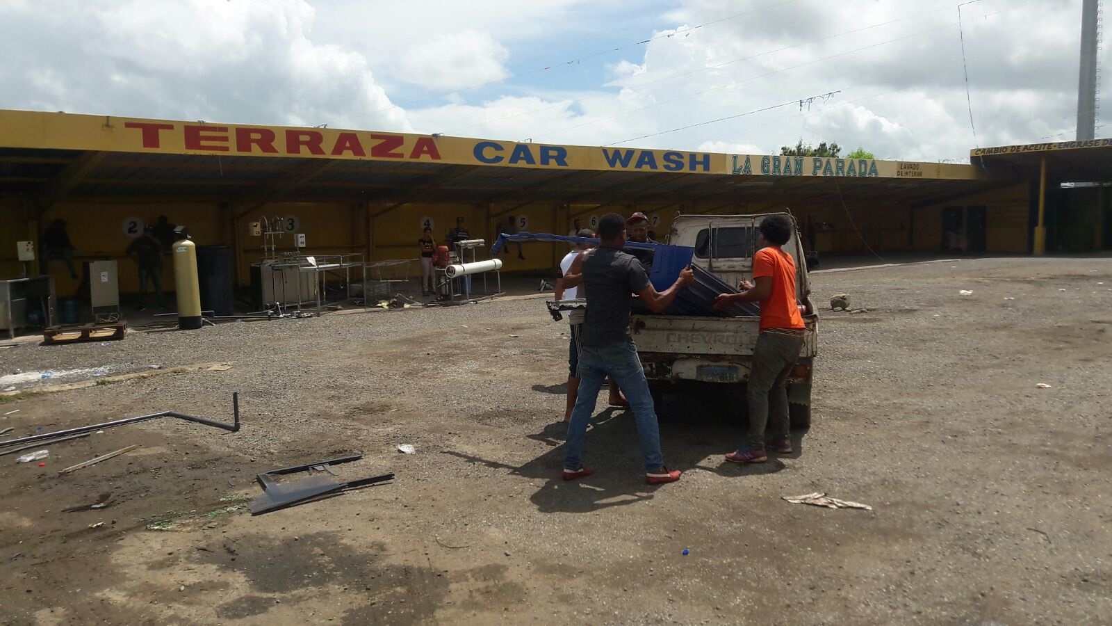 Hombres recogen metal del área desalojada. 