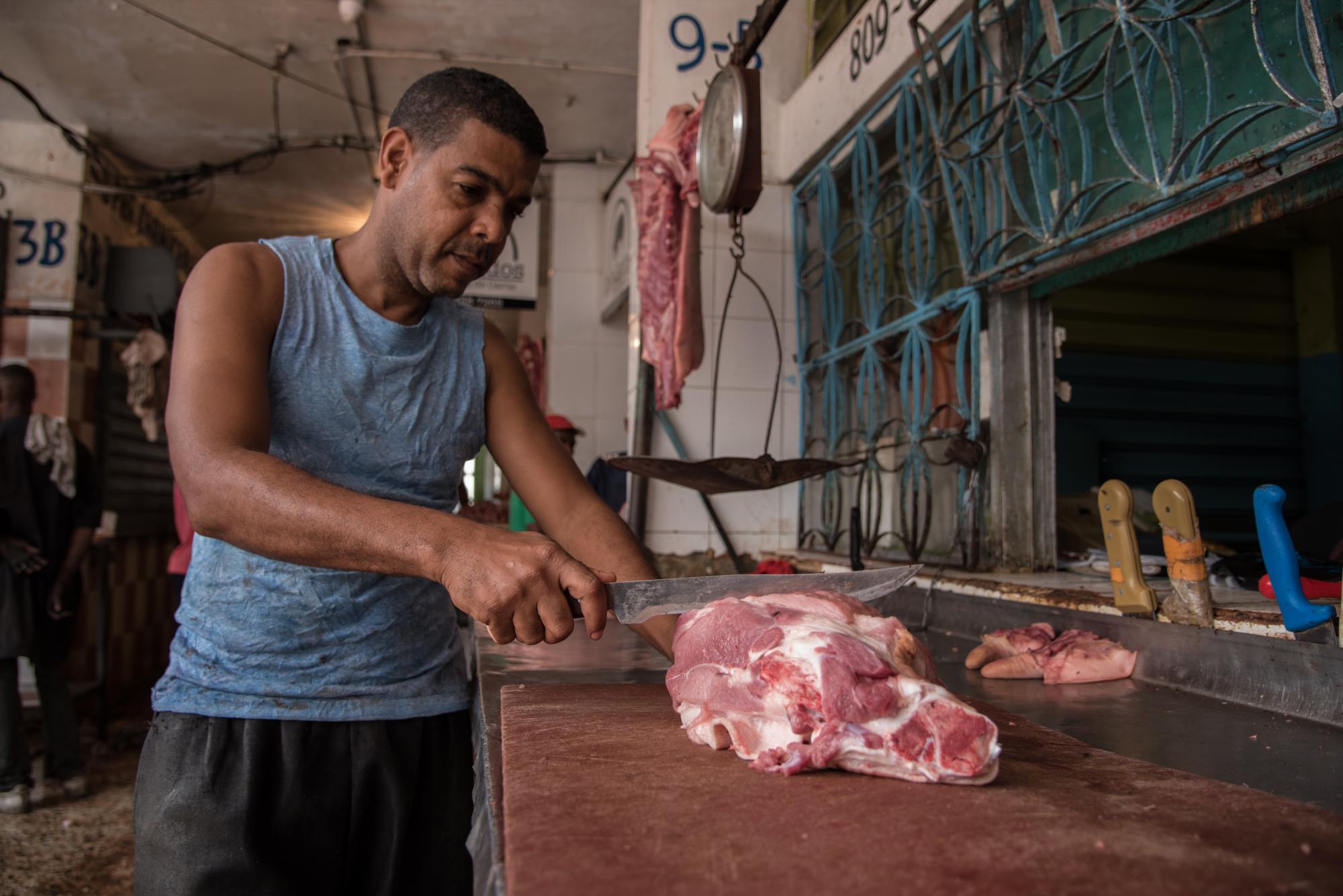 José Antonio Herrera corta un trozo de carne en su puesto.