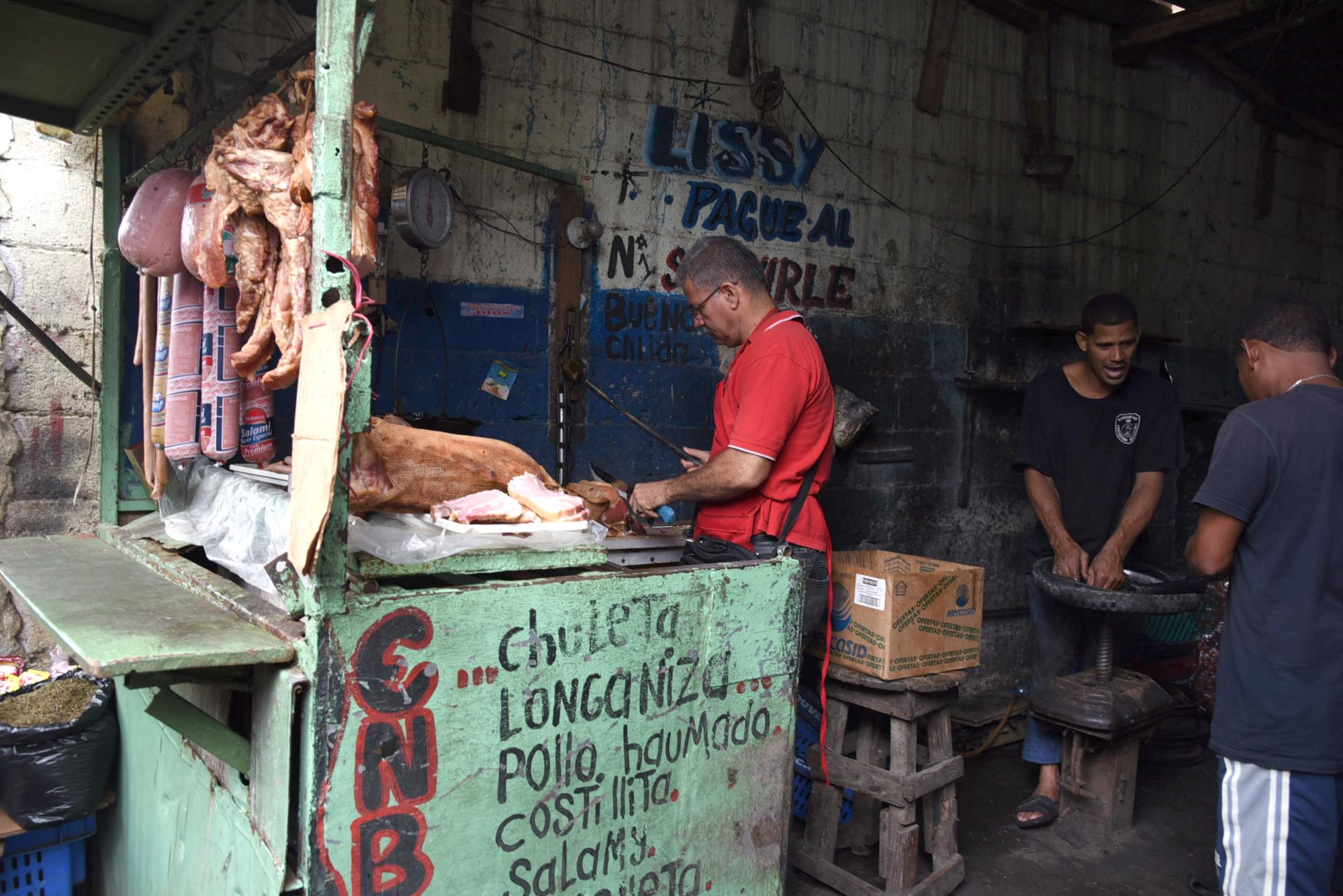 Un puesto de venta en el mismo local donde funciona un taller de mecánica en un mercado informal de Sabana Perdida.