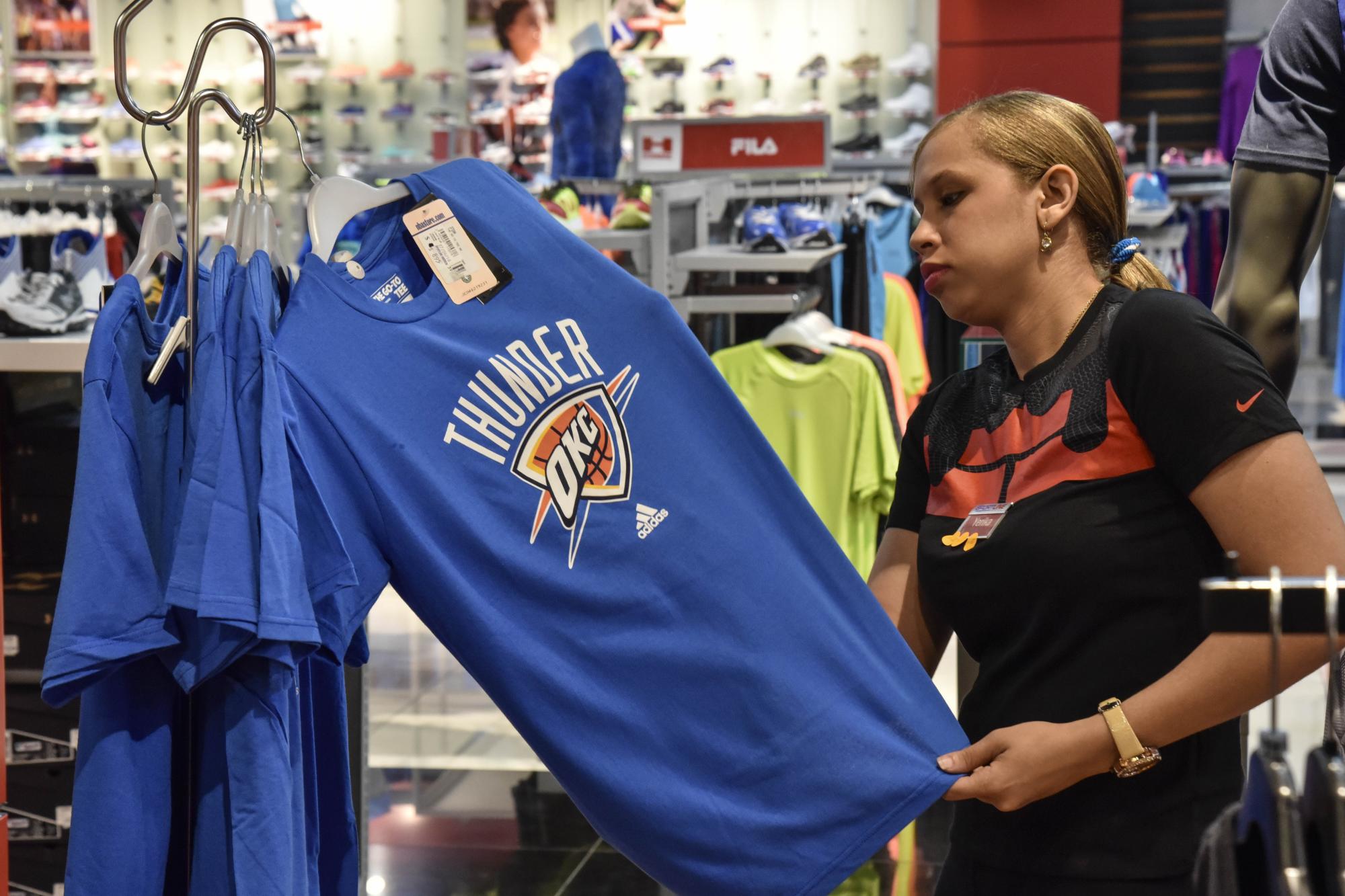 Una de las empleadas de Jordán SportLine muestra una de las camisetas que ofrecen.  