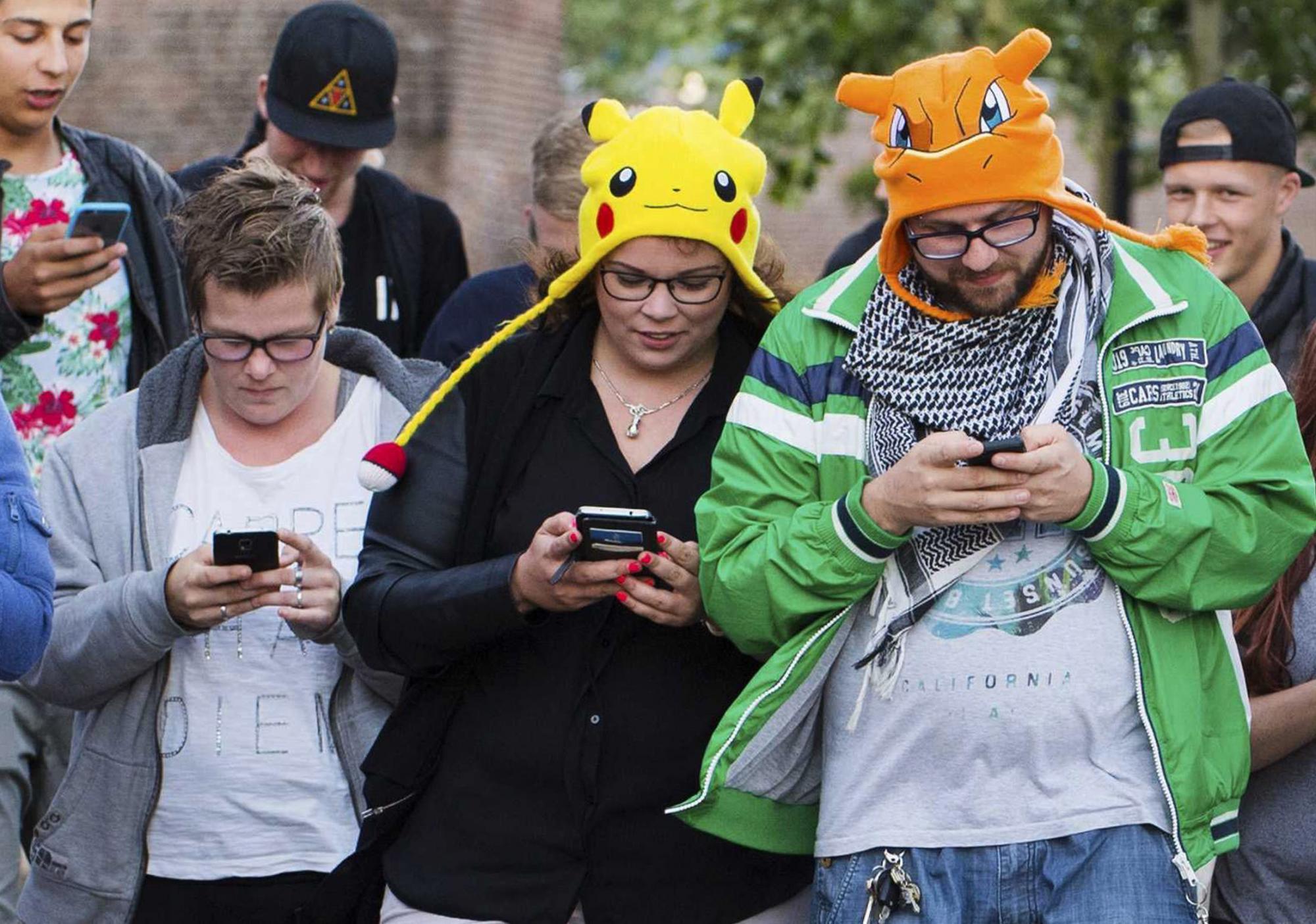 Fotografía de archivo tomada el 11 de julio de 2016 que muestra a un grupo de personas mientras juegan al videojuego Pokémon Go con sus móvile. 